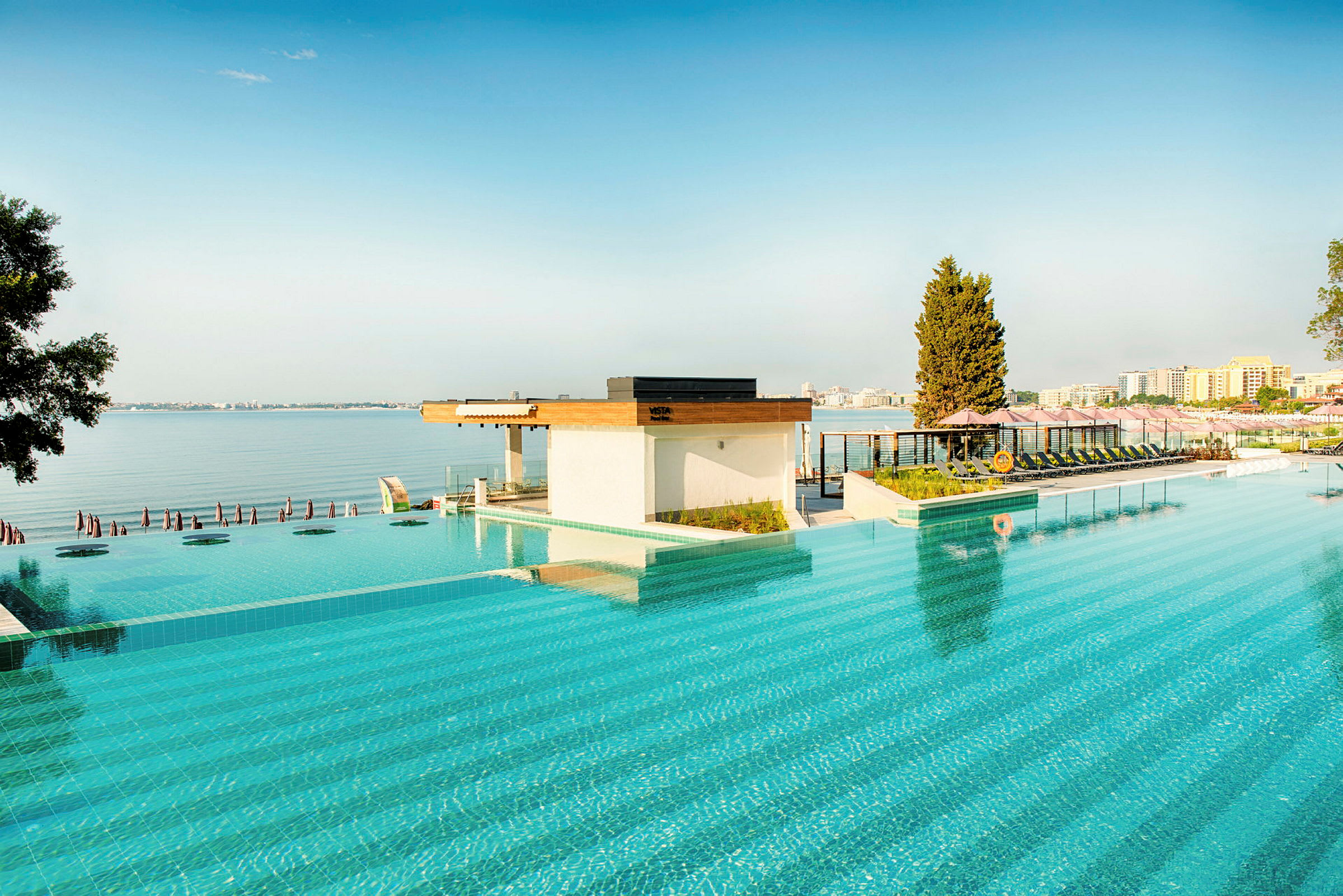 En pool med utsikt över havet och stadssiluetten. (AI-genererad text)