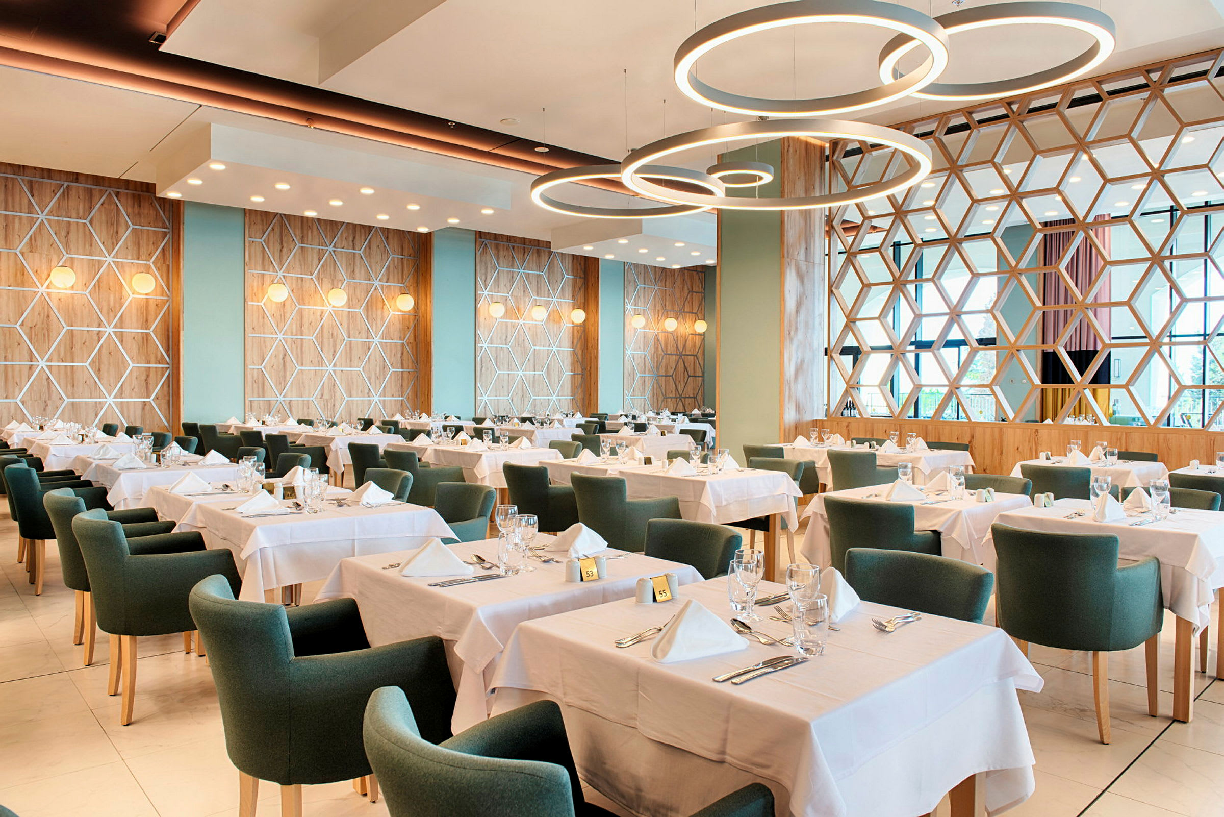 Bild av en restaurang med dukade bord och gröna stolar. (AI-genererad text)