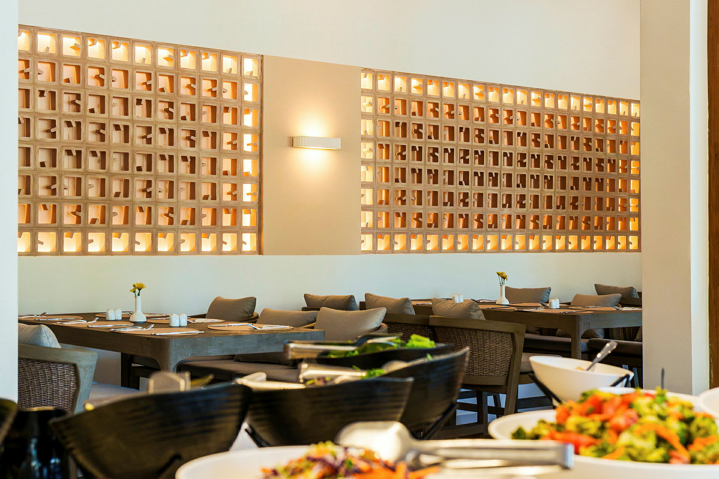 Ett upplyst matbord med stolar och dekorativ vägg i en restaurang. (AI-genererad text)