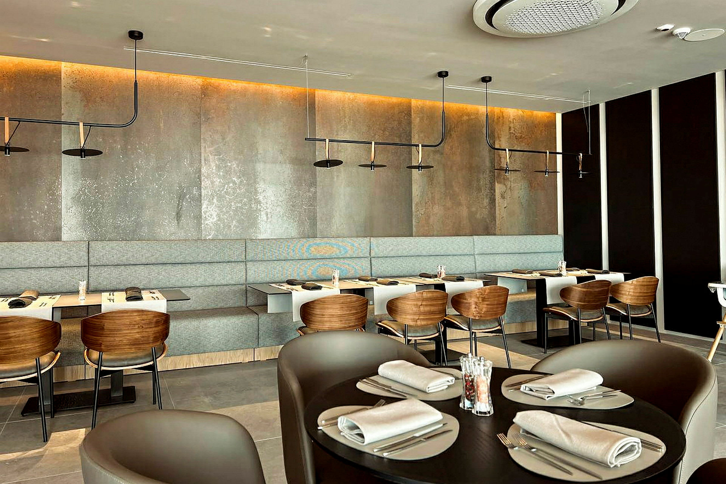 En modern restaurang med bord, stolar och en bänksits längs väggen. (AI-genererad text)