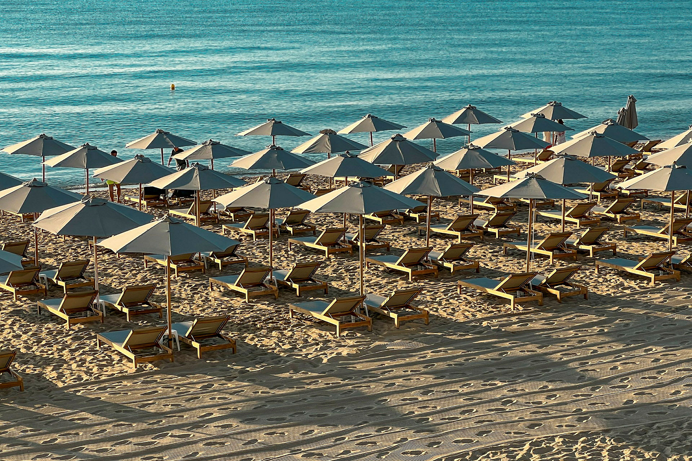 En strand med solstolar och parasoller. (AI-genererad text)