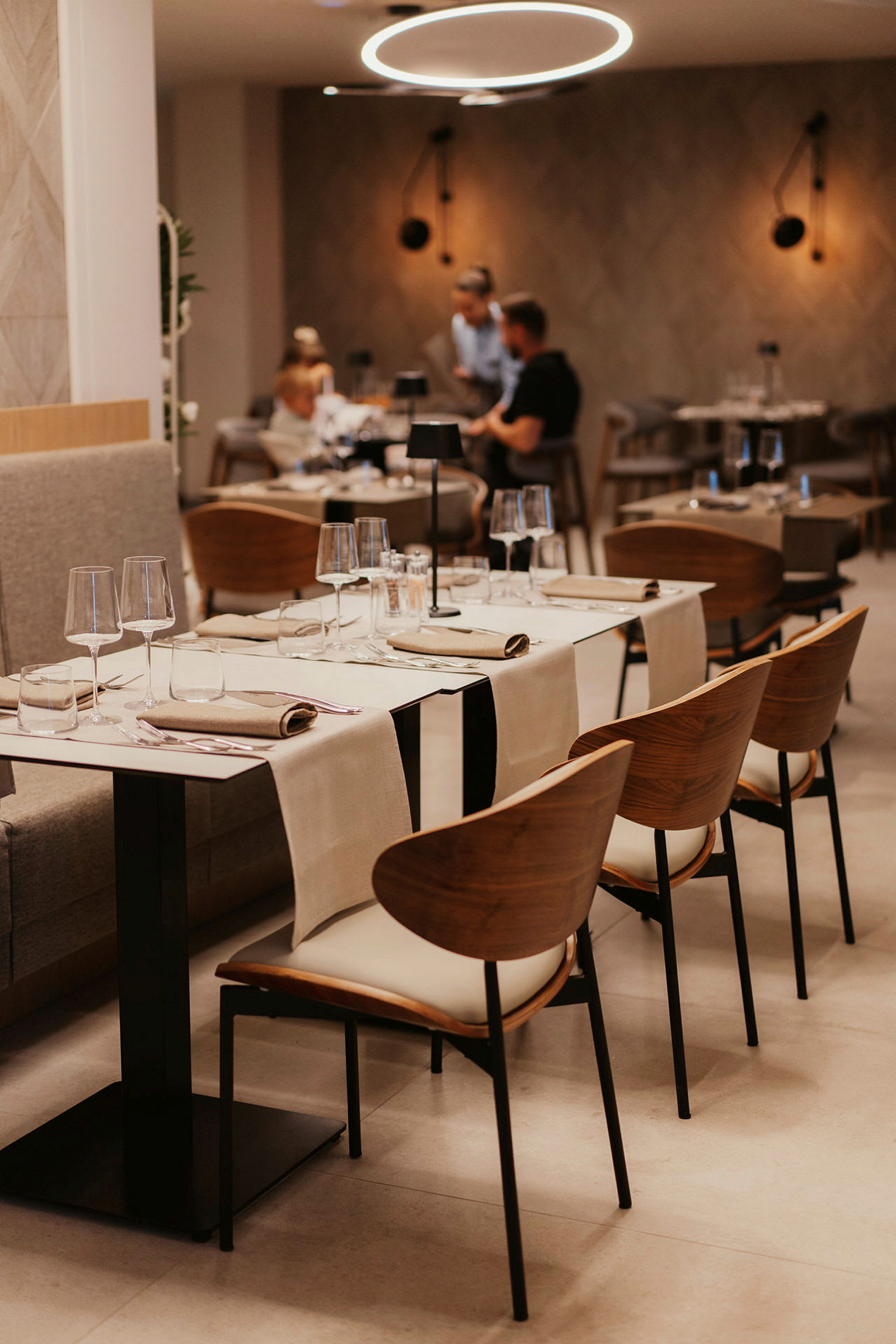 Ett modernt inrett restaurangområde med dukade bord och eleganta stolar. (AI-genererad text)