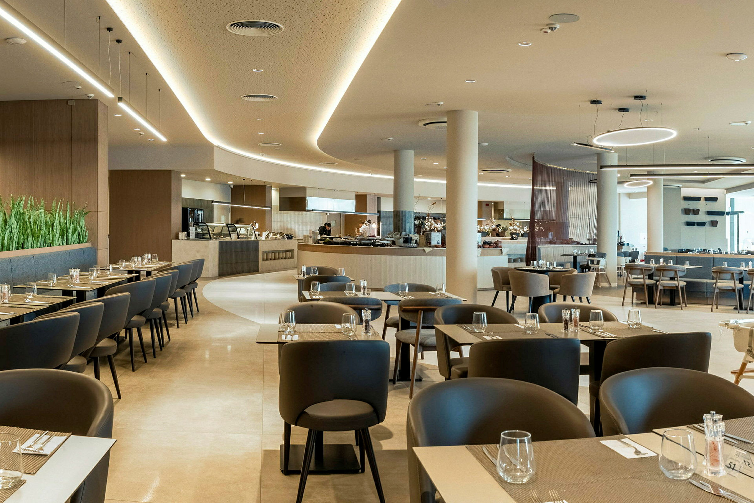 Modernt och ljust inrett restaurangområde med bord och stolar. (AI-genererad text)
