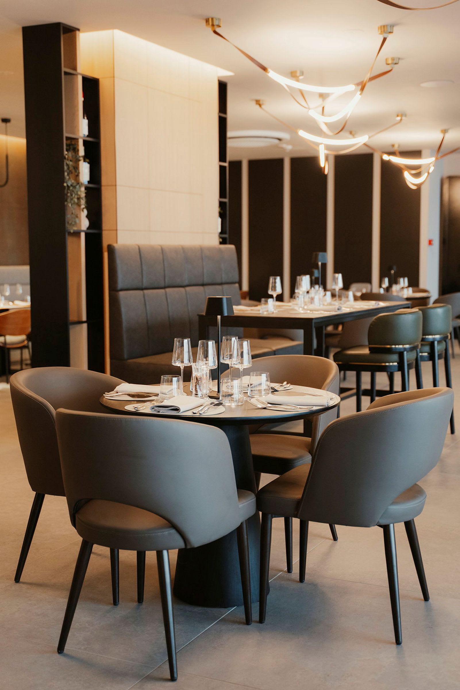 Interiör av en modern restaurang med dukade bord och stolar. (AI-genererad text)