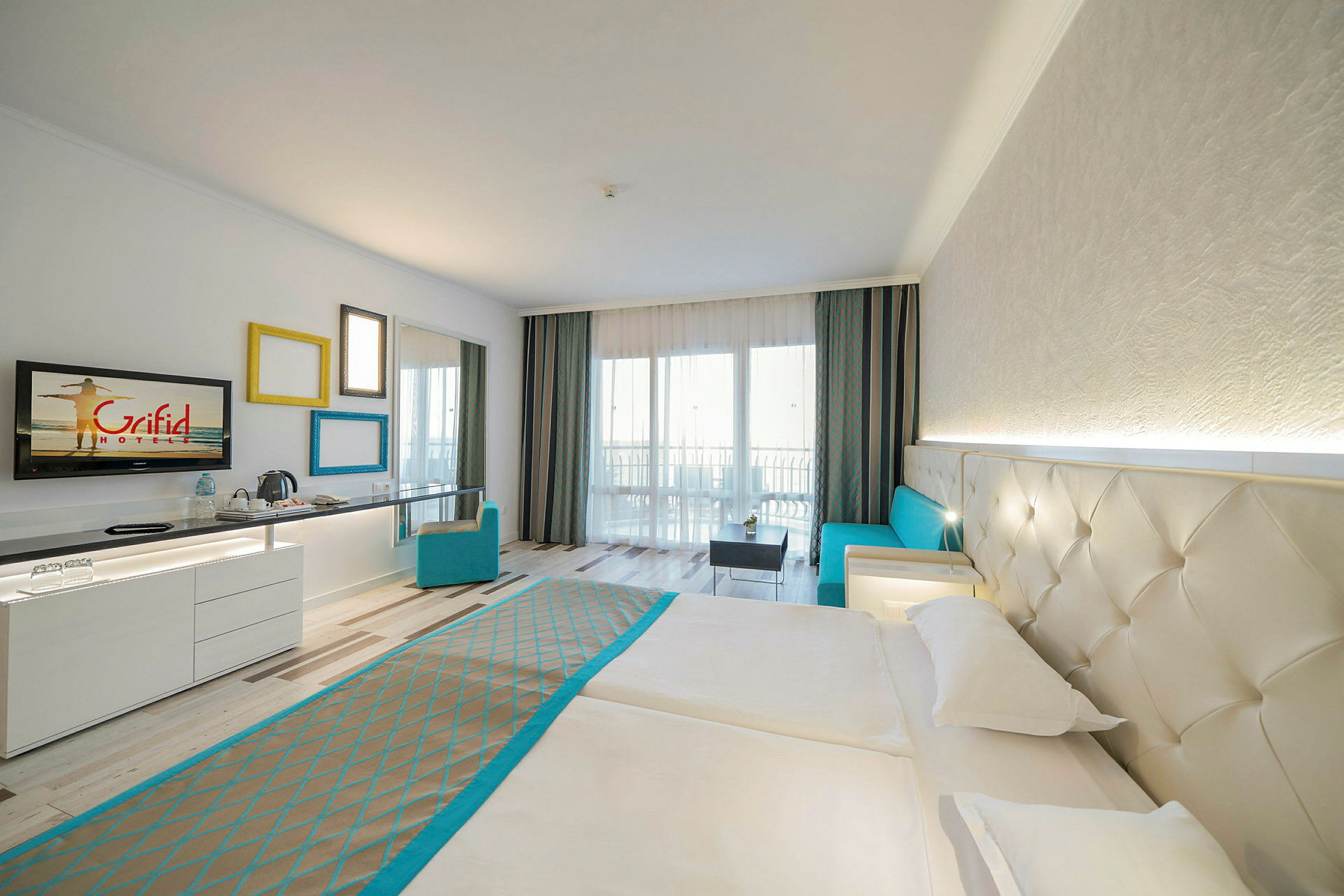 Hotellrum med dubbelsäng, soffa och skrivbord. (AI-genererad text)