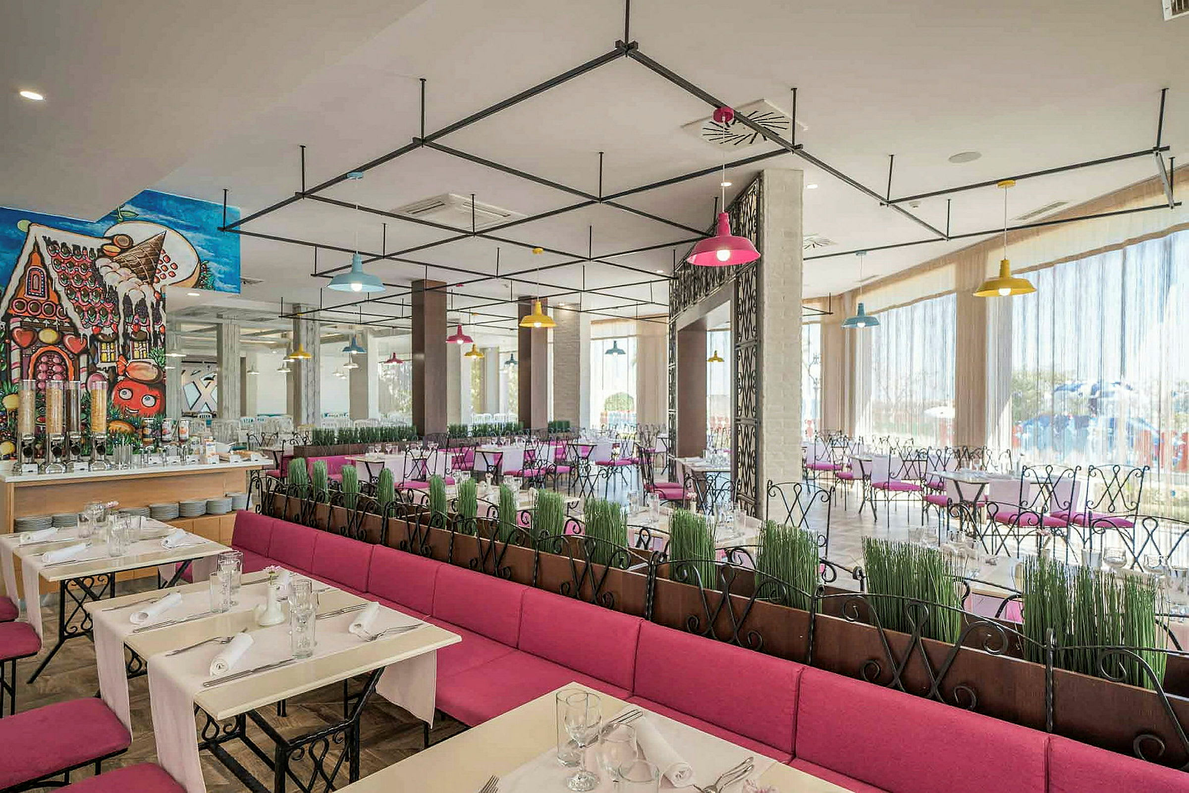 Modernt inrett restaurangområde med färgglada lampor och rosa sittplatser. (AI-genererad text)