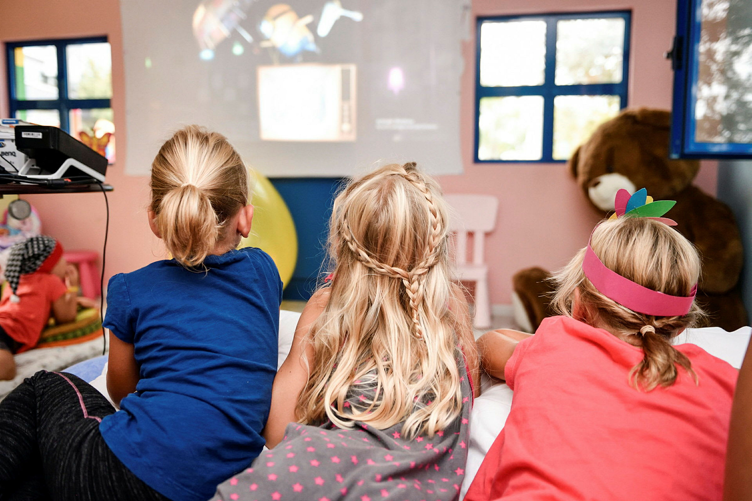 Barn tittar på en film i ett lekrum. (AI-genererad text)