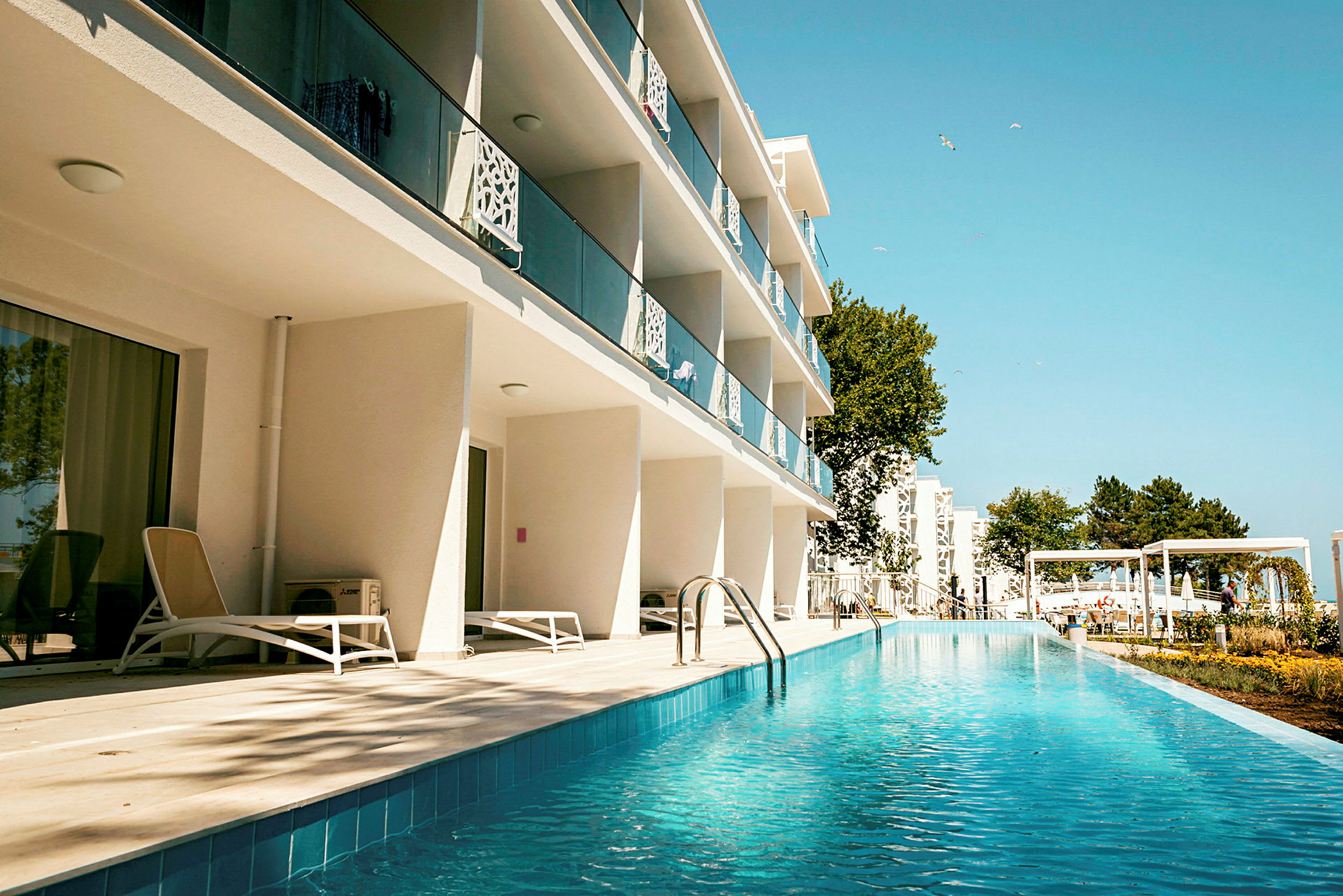 Hotellbyggnad med balkonger och poolområde. (AI-genererad text)