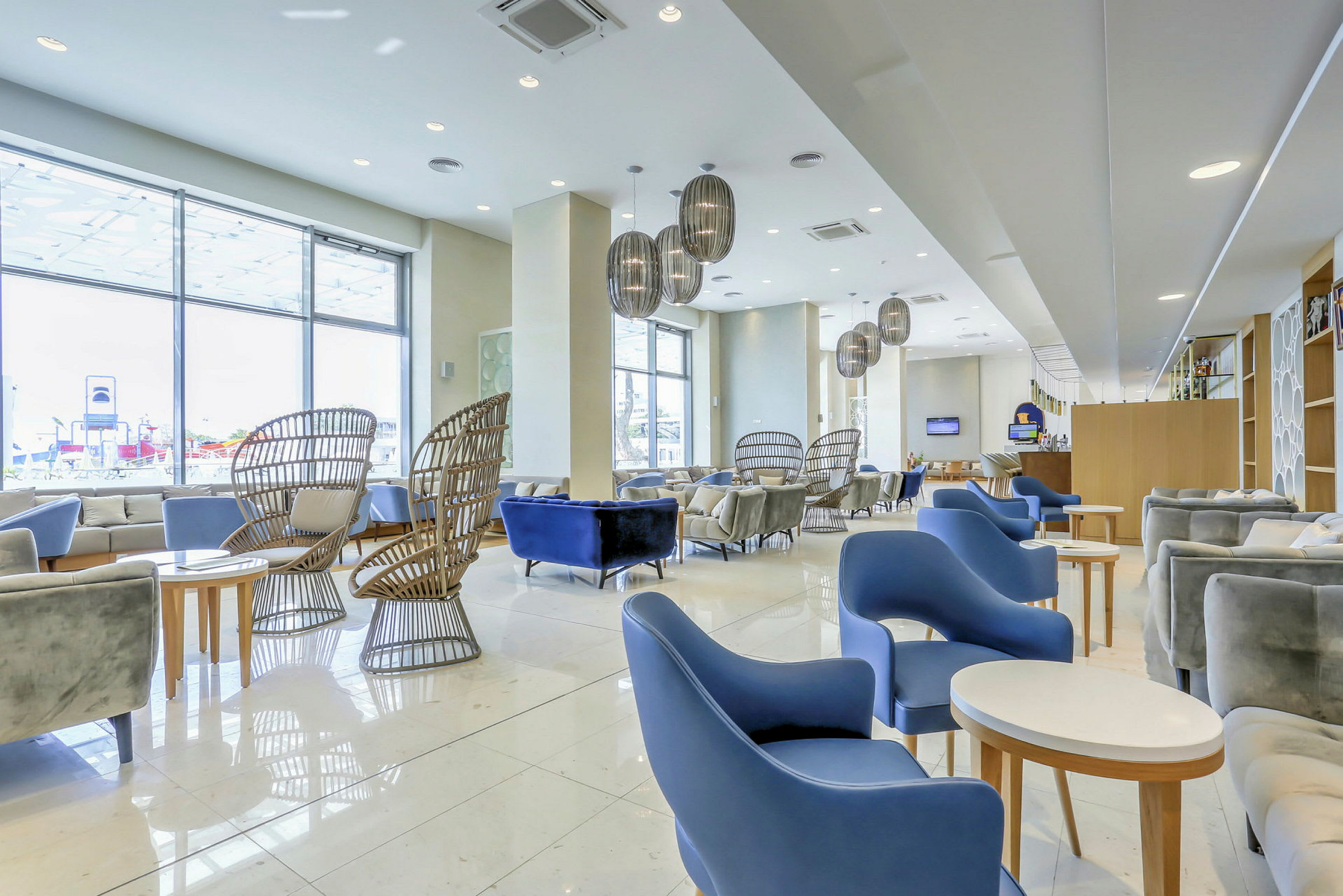 En hotellobby med moderna möbler och stora fönster. (AI-genererad text)