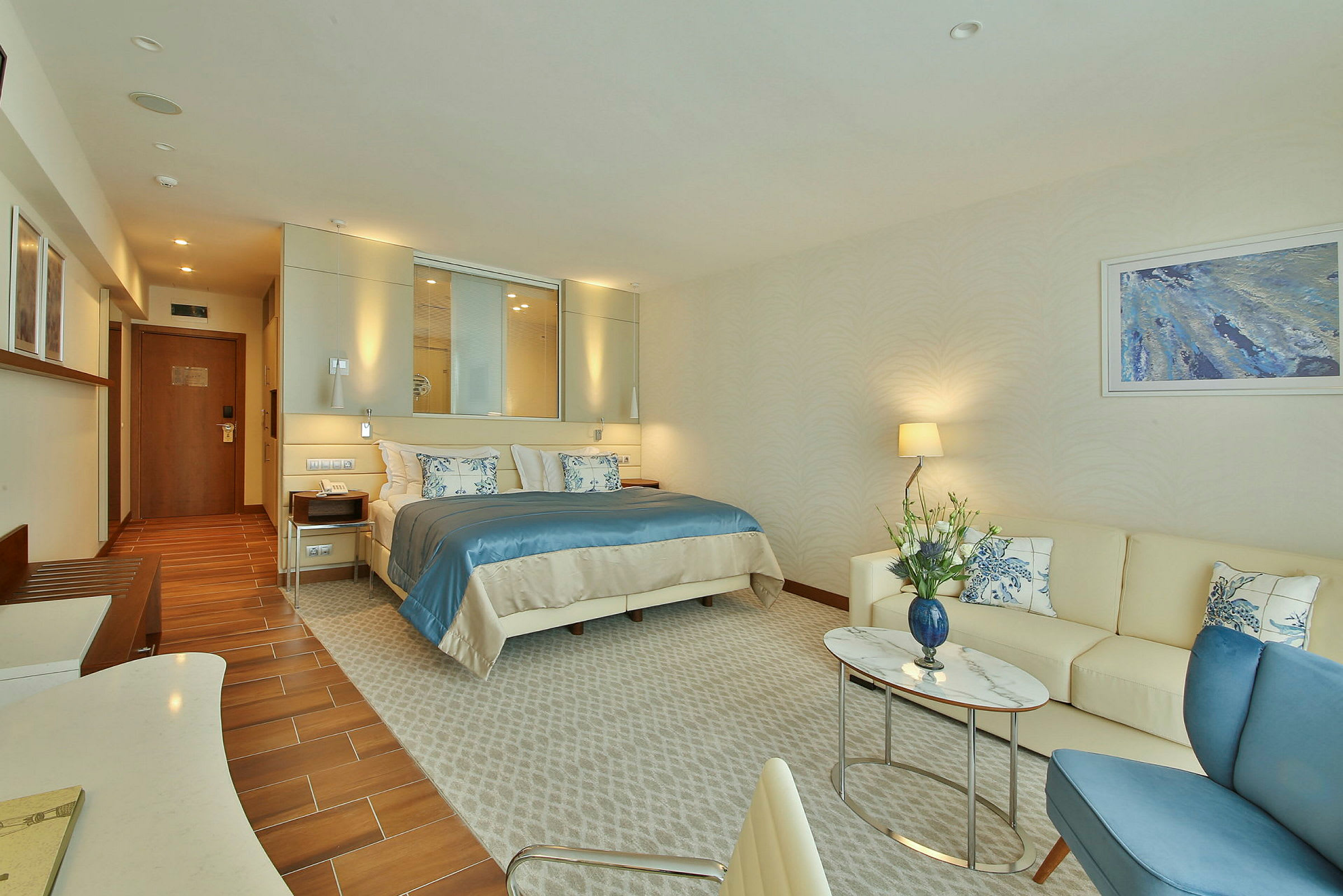 Ett hotellrum med en dubbelsäng, en soffa och ett soffbord. (AI-genererad text)