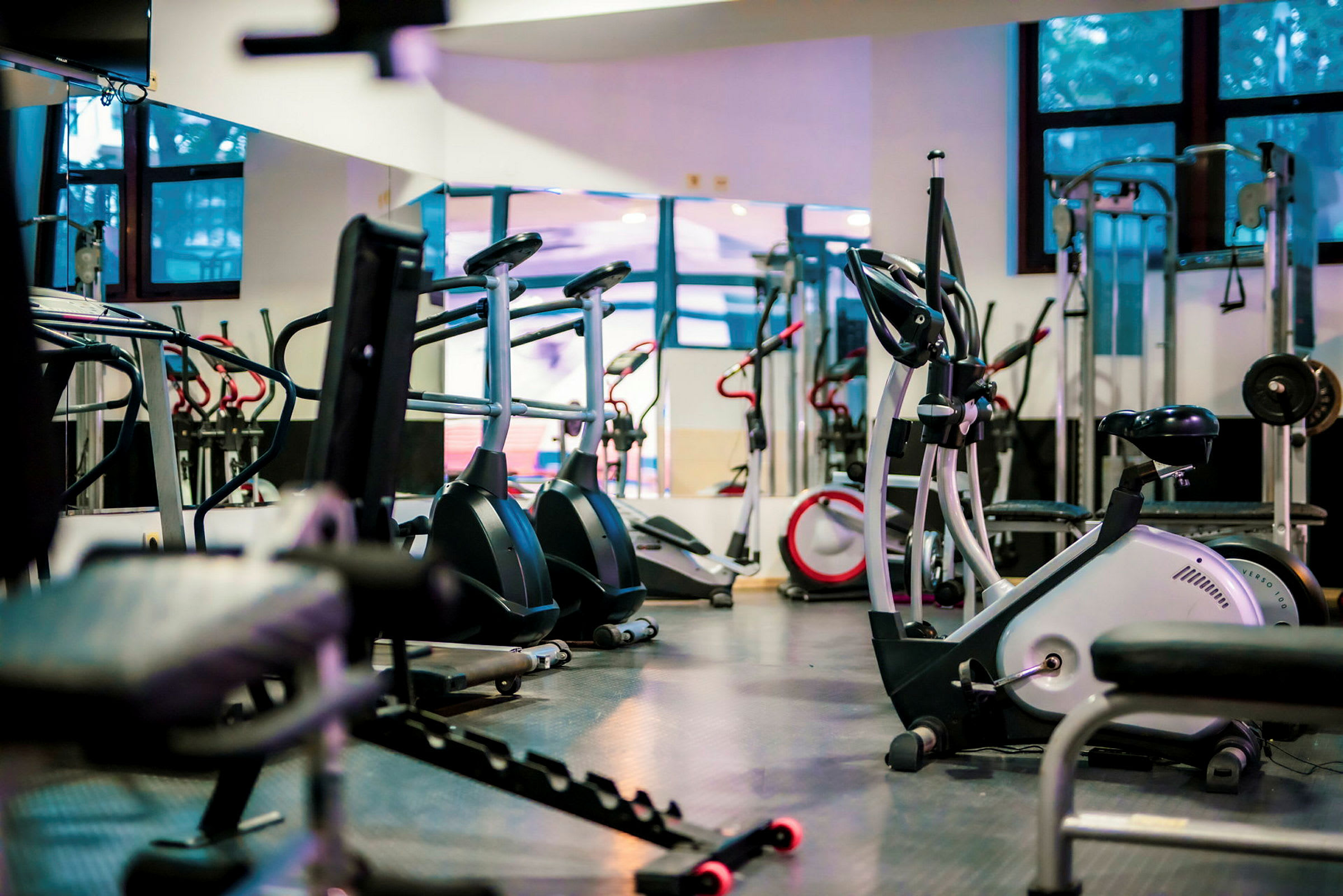 Gym med träningsmaskiner, motionscyklar och styrketräningsutrustning. (AI-genererad text)