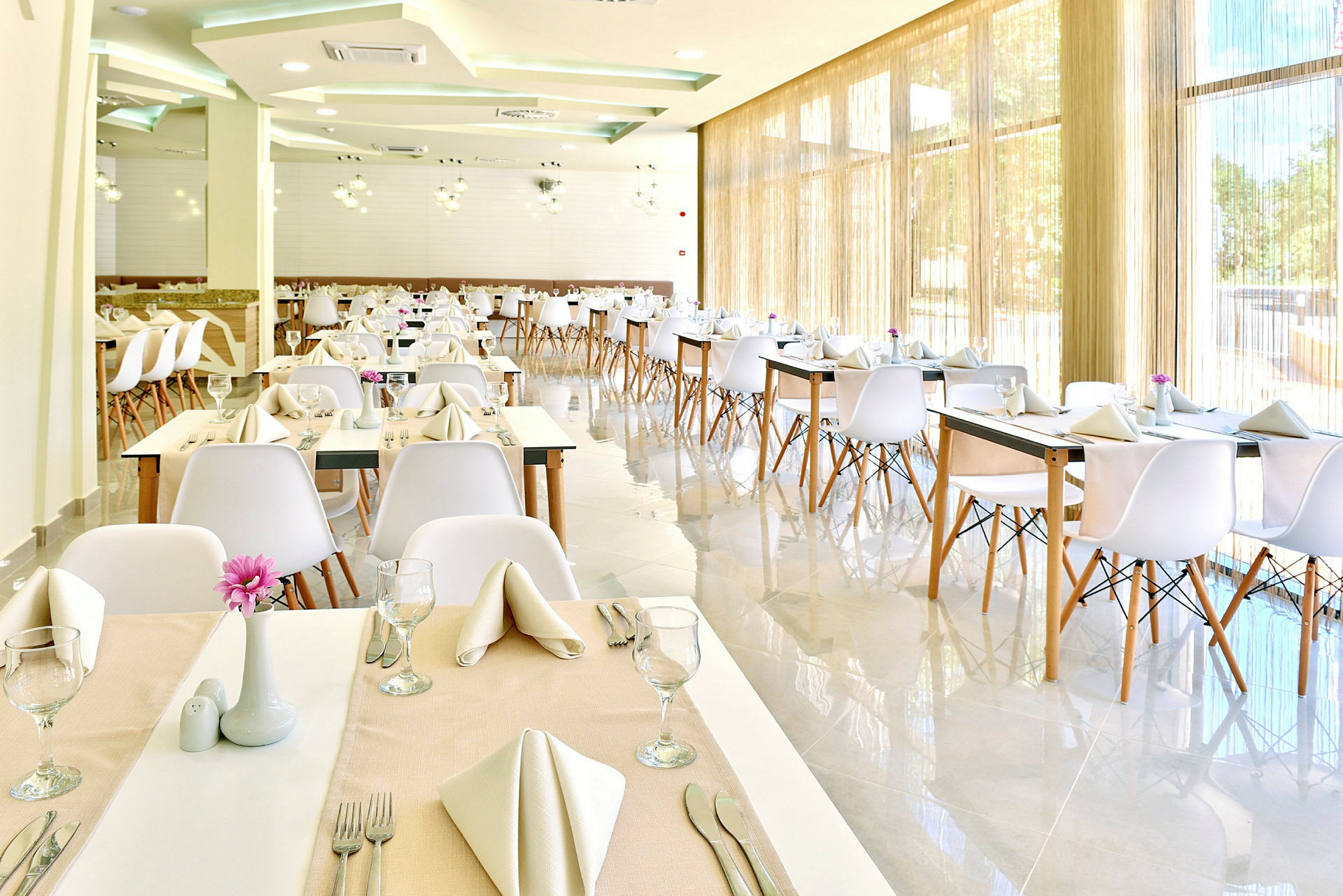 Modern restaurang med dukade bord och vita stolar. (AI-genererad text)