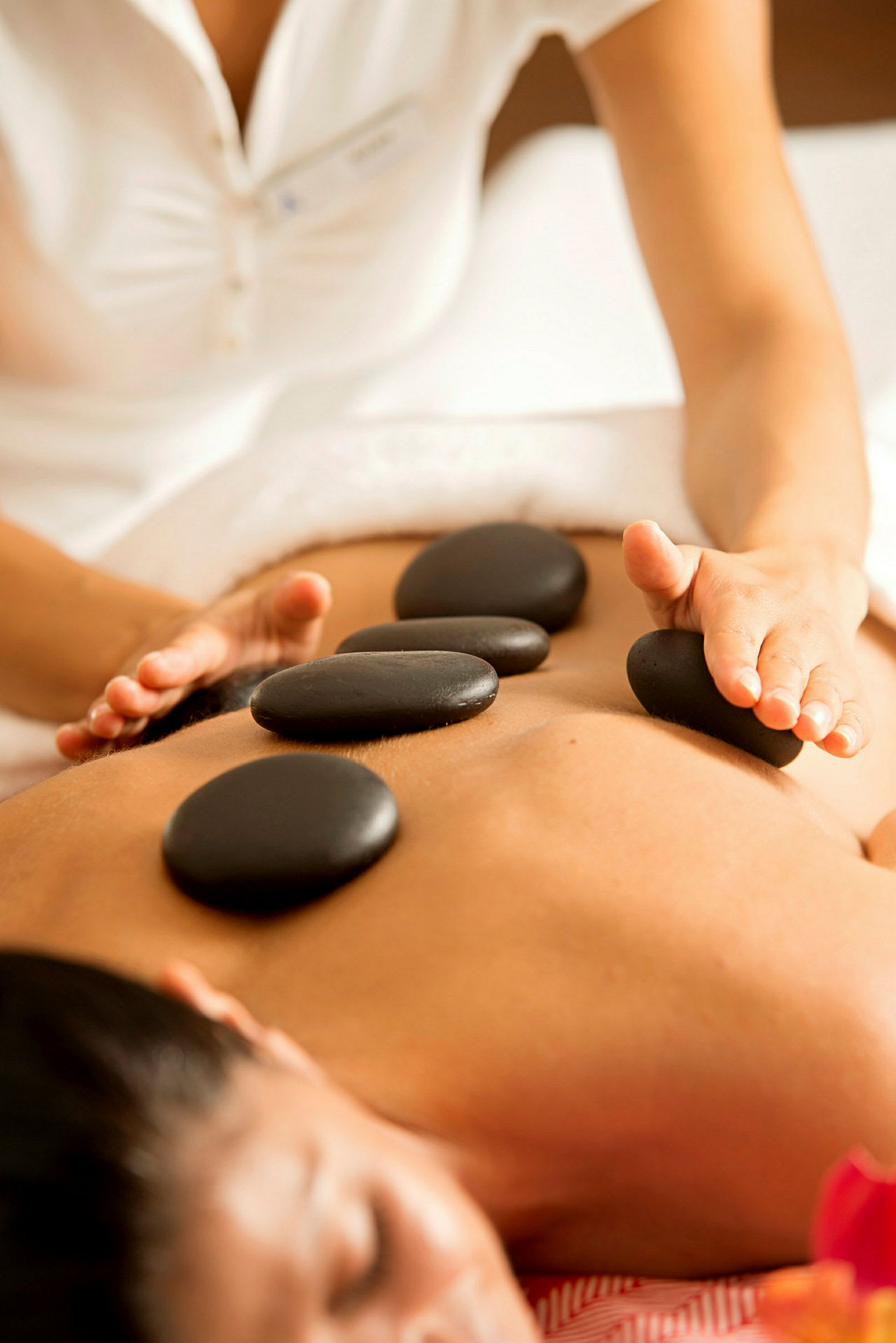 En person får hot stone-massage. (AI-genererad text)