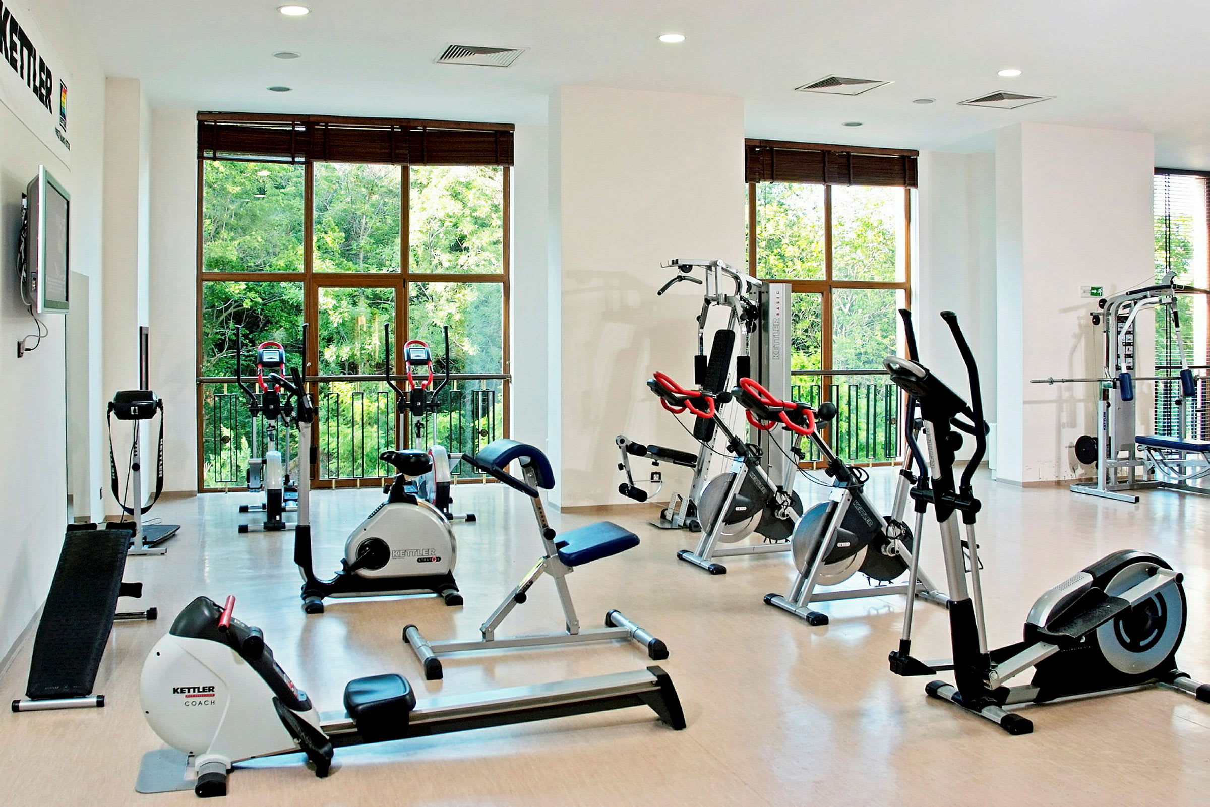 Ett gym med träningsutrustning och stora fönster. (AI-genererad text)