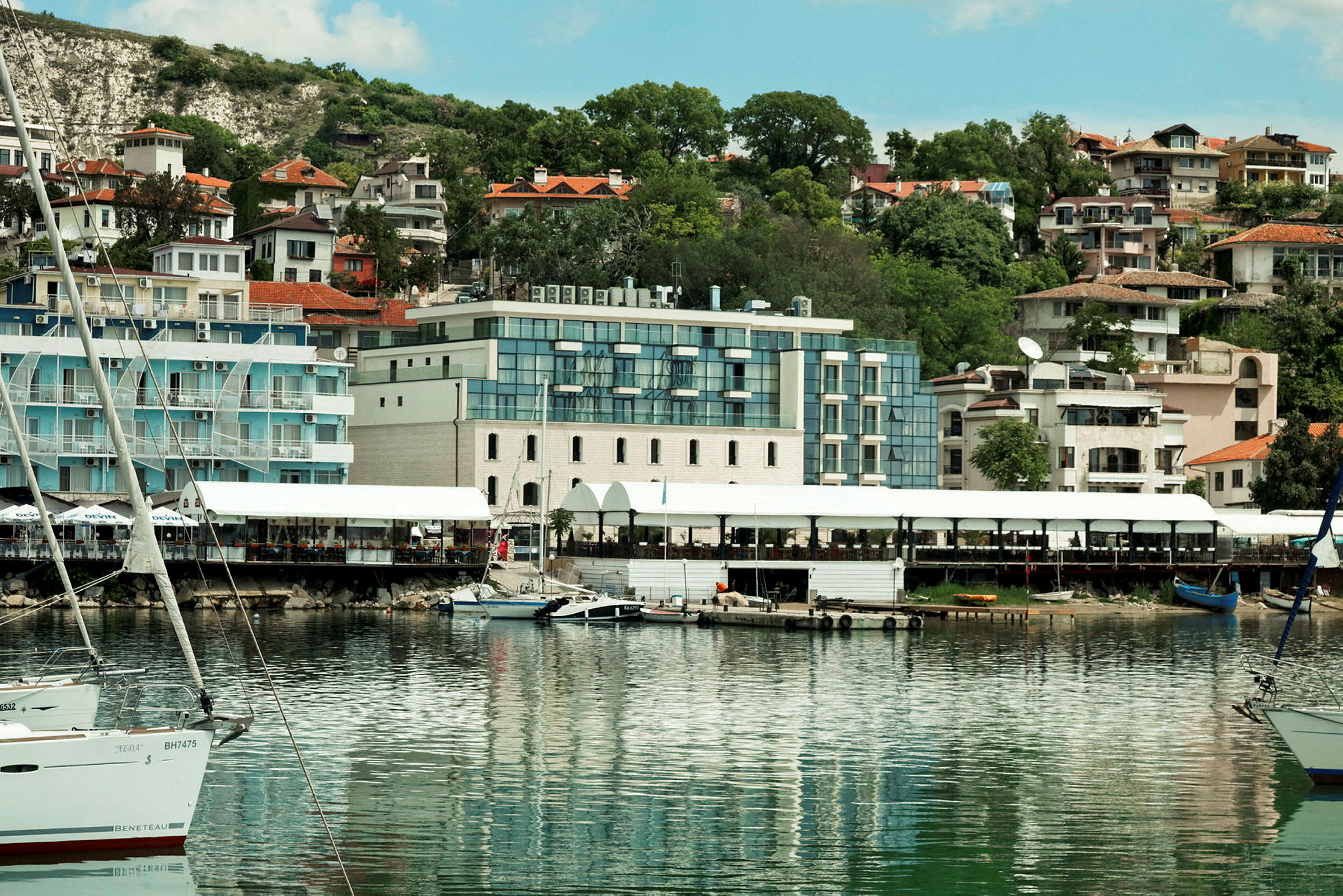 Bild av en hamn med båtar och byggnader i bakgrunden. (AI-genererad text)