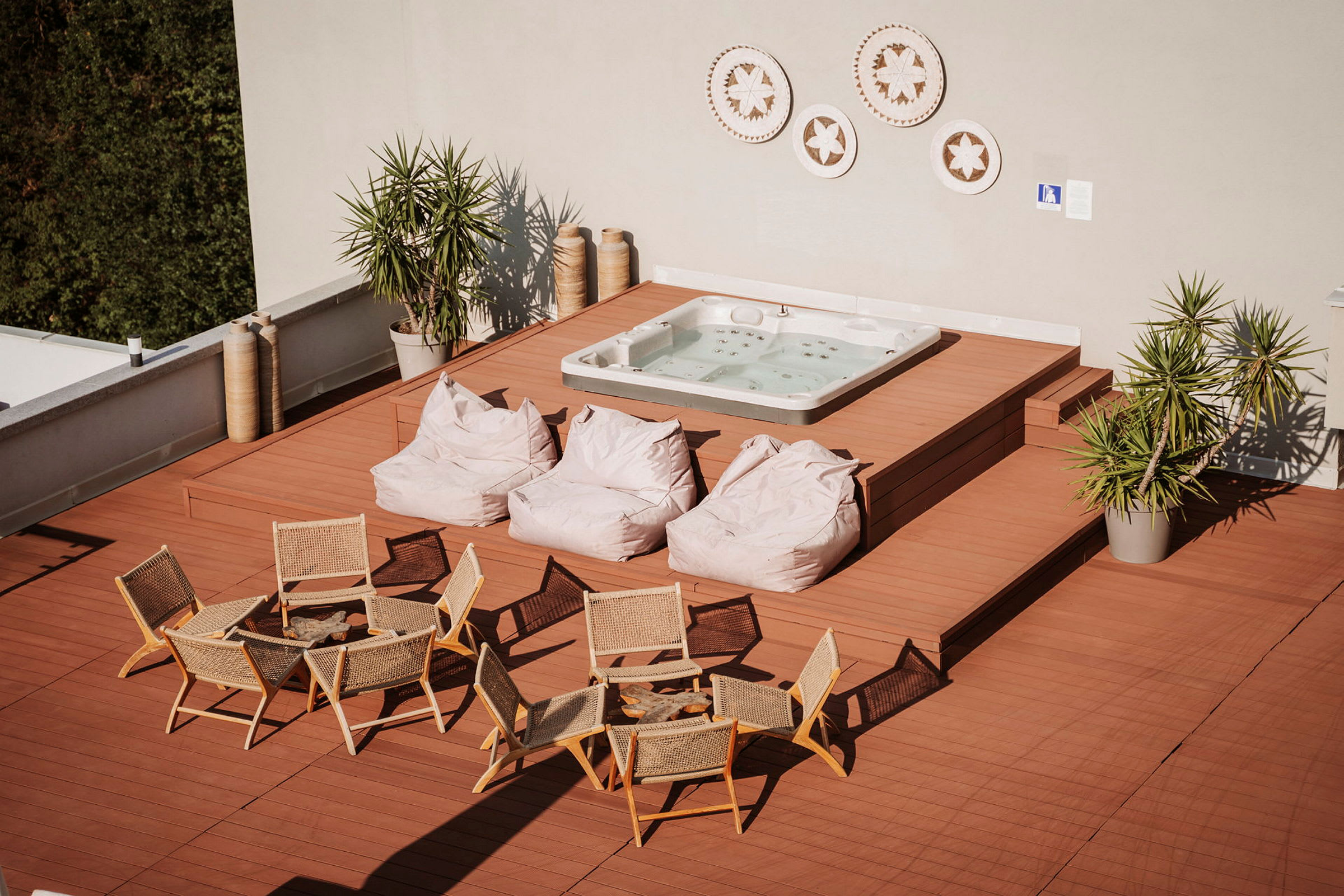 Ett trädäck med sittplatser, puffar och en jacuzzi. (AI-genererad text)