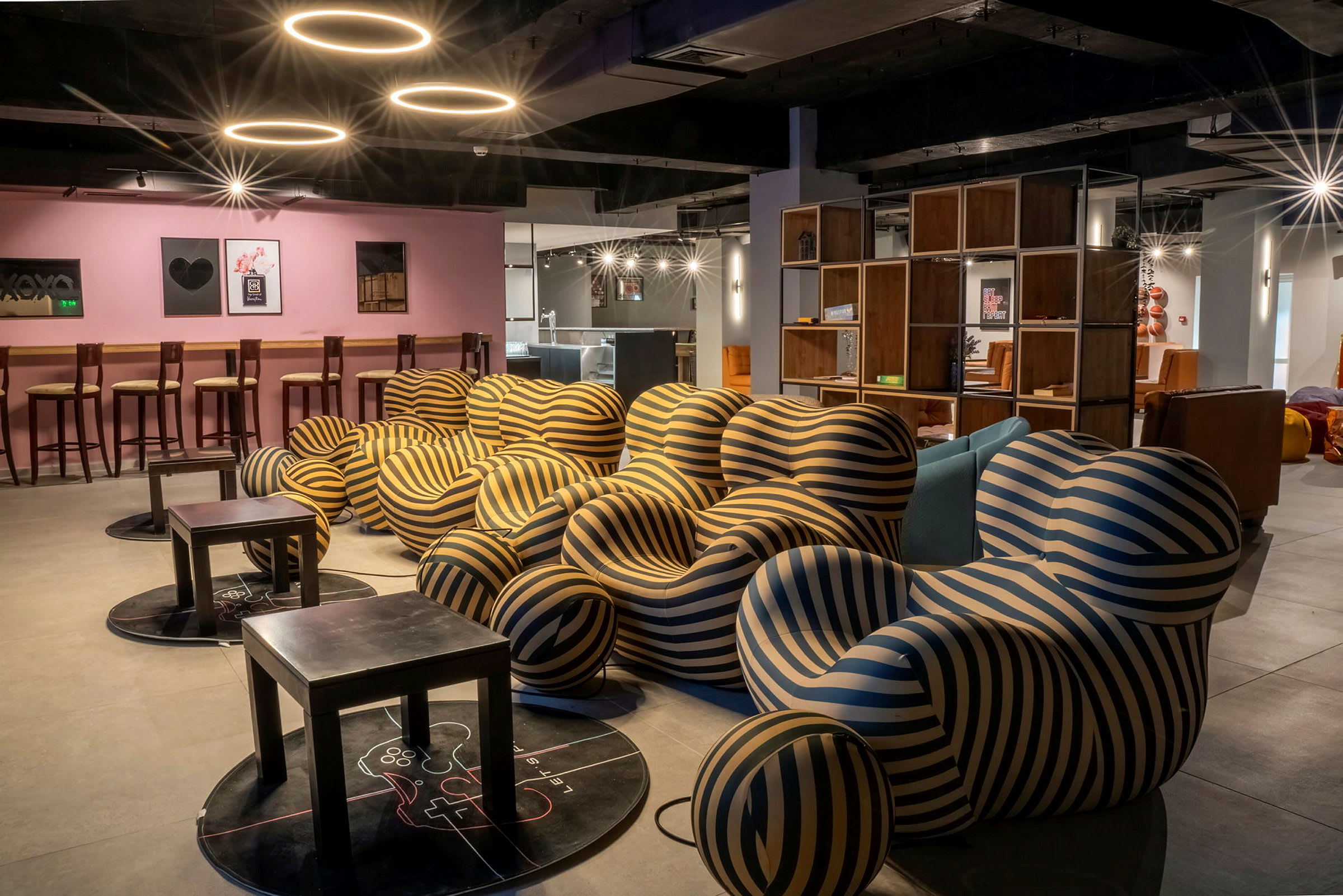 En loungemiljö med moderna randiga fåtöljer och små bord. (AI-genererad text)