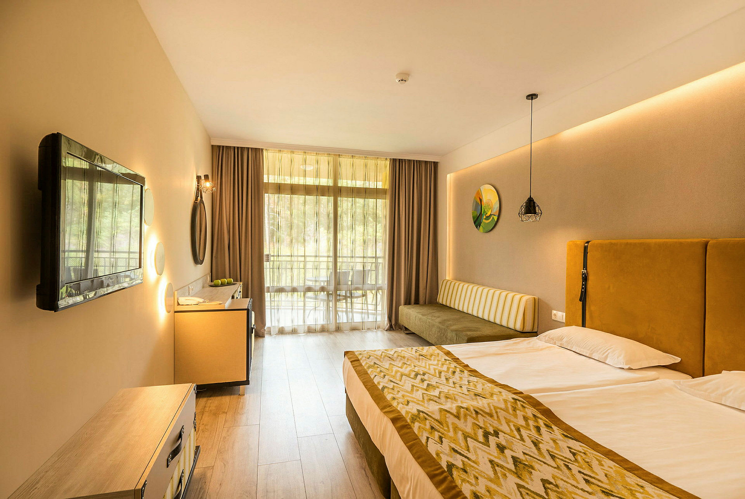 Ett hotellrum med en dubbelsäng, en soffa, en tv och en balkong. (AI-genererad text)