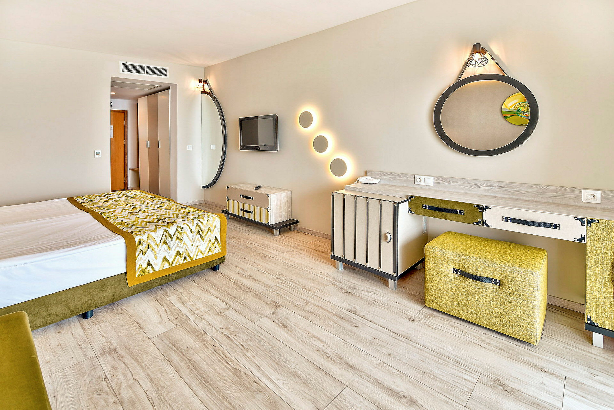 Ett hotellrum med modern inredning, inklusive en säng, speglar och ett skrivbord. (AI-genererad text)