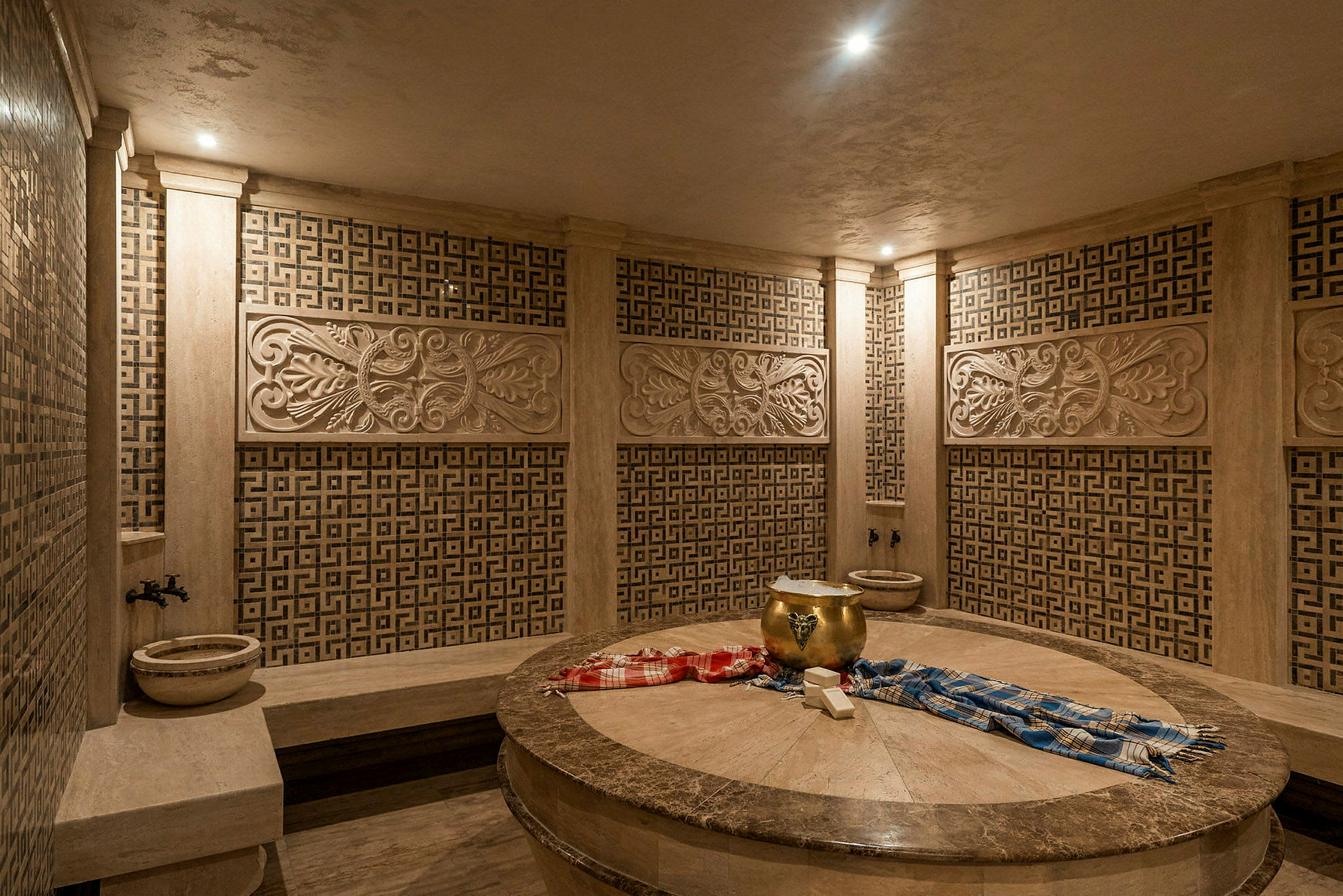 En traditionell hamam med dekorerade väggar och central stenyta. (AI-genererad text)