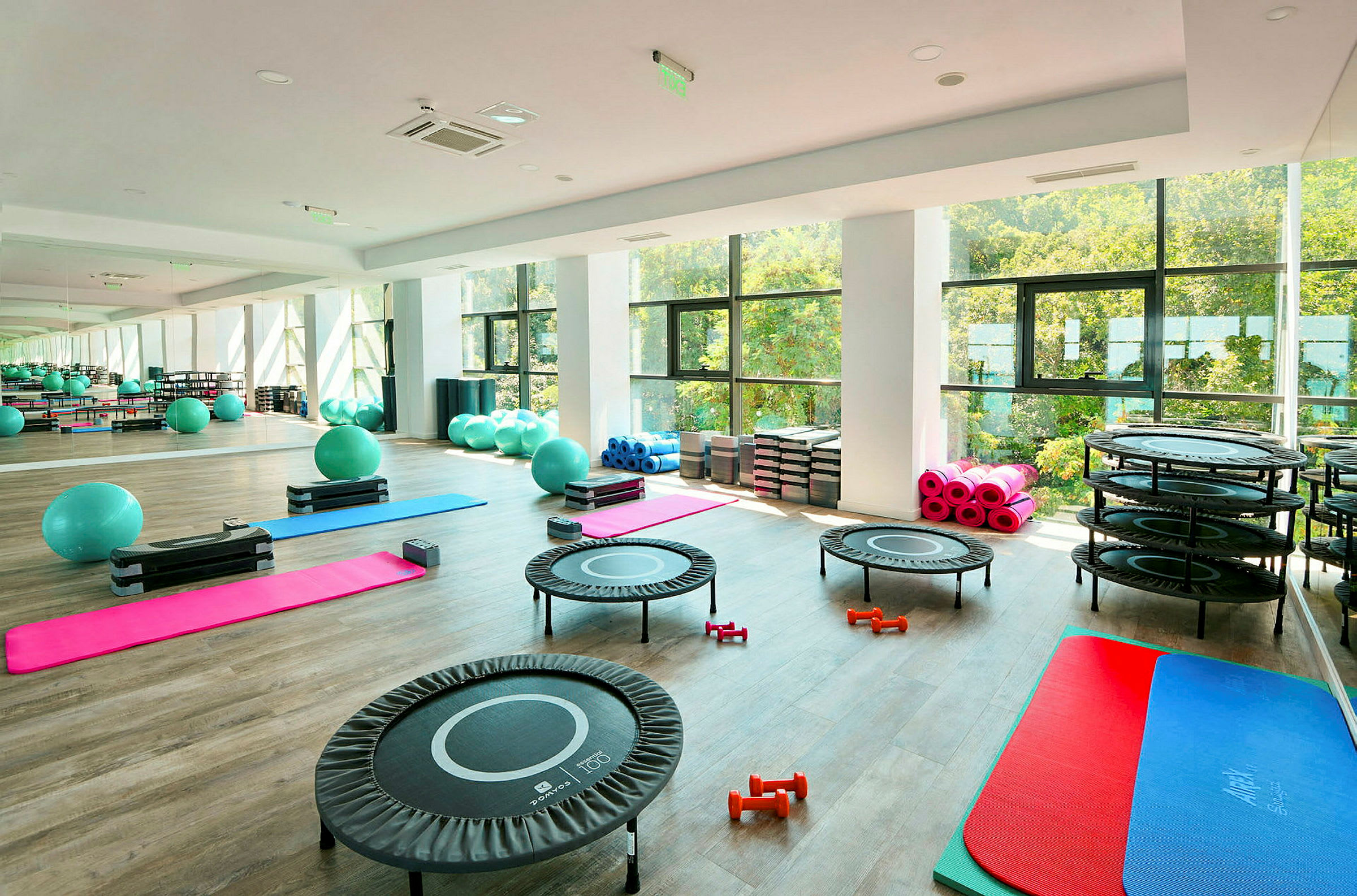 Gym med träningsutrustning som pilatesbollar, trampoliner och träningsmattor. (AI-genererad text)