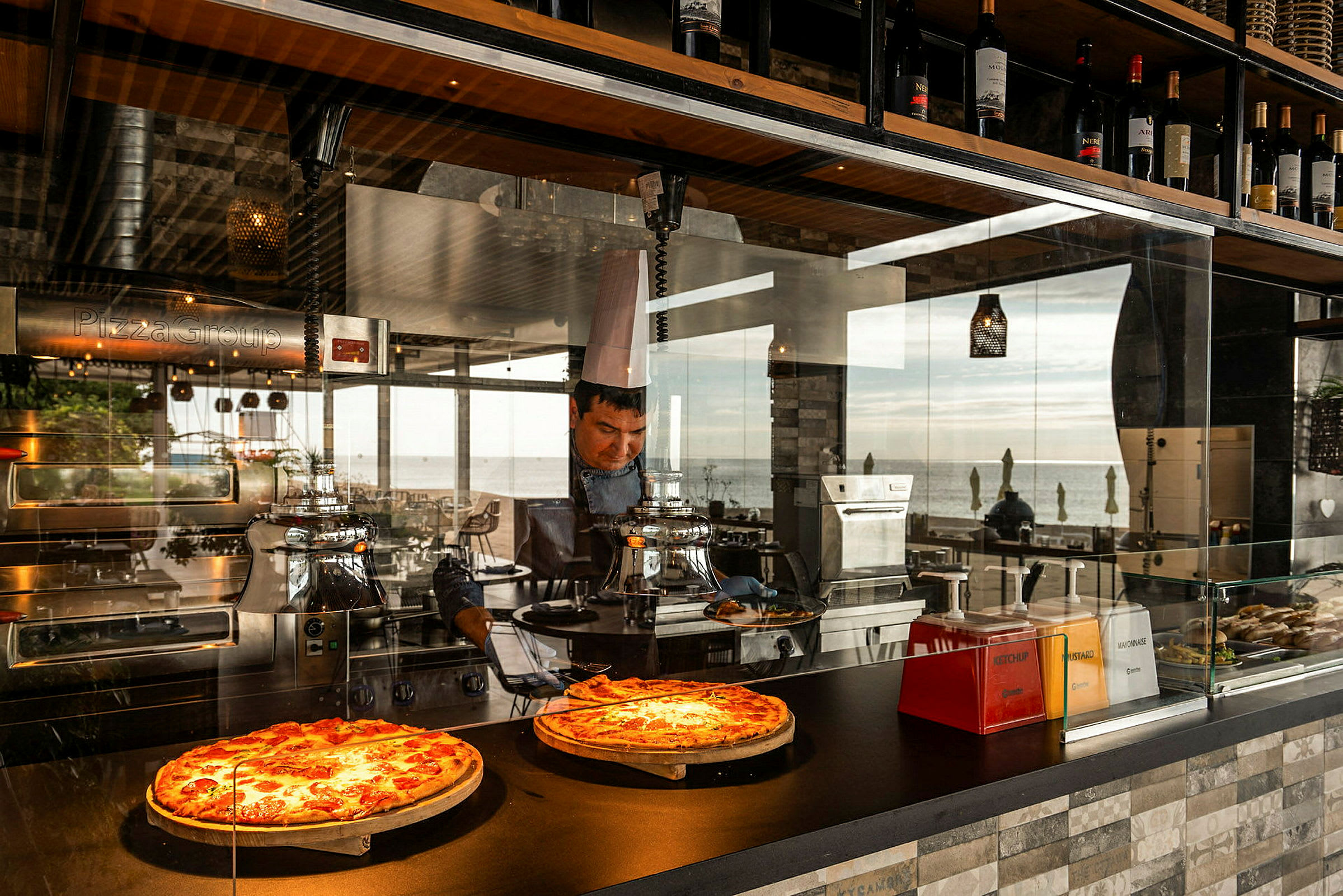 Två pizzor på display i en restaurang med havsutsikt. (AI-genererad text)