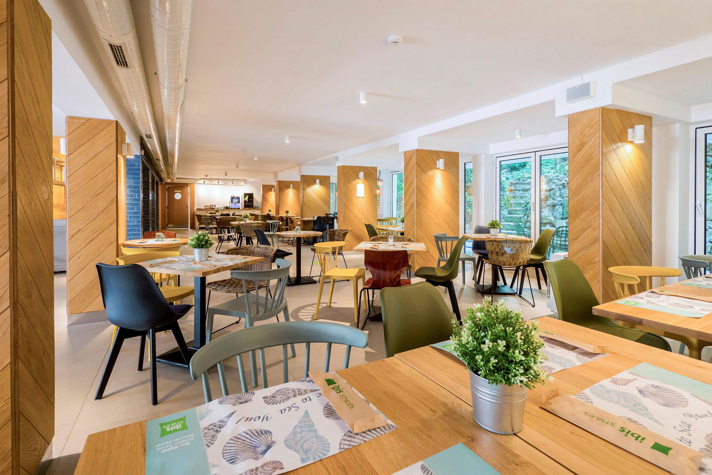 Bild av en restaurang med bord, stolar och dekorationer. (AI-genererad text)