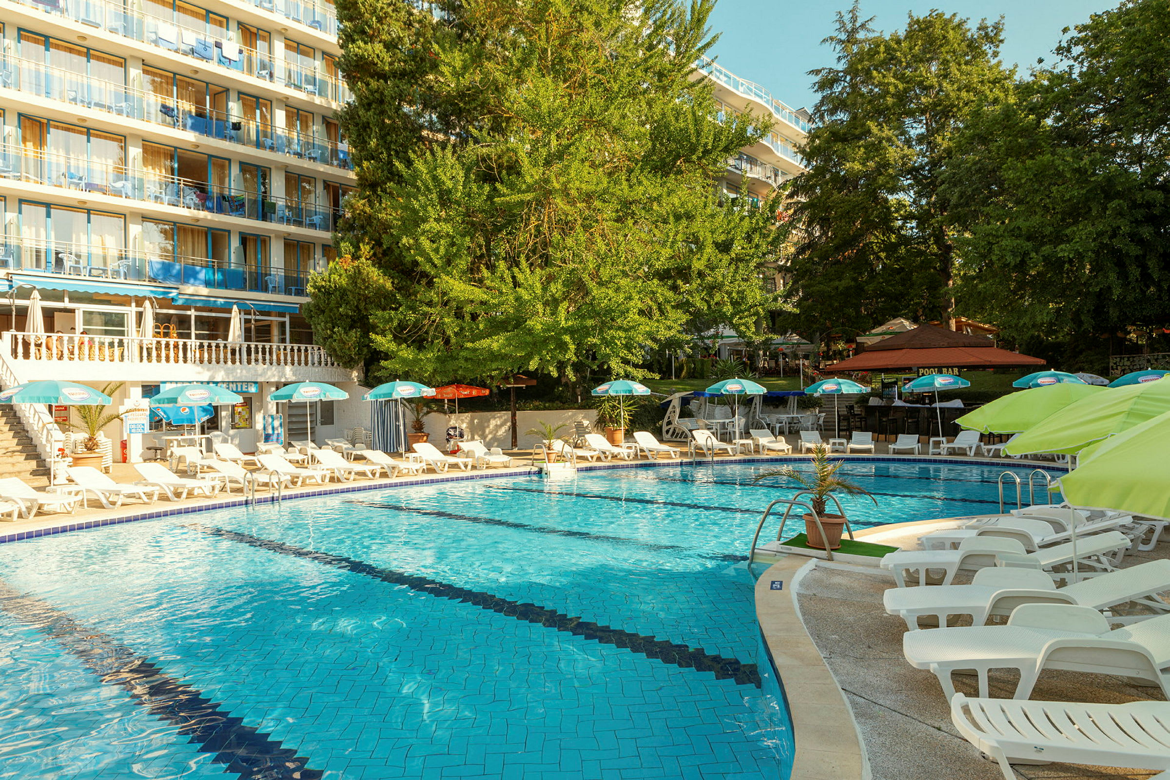 Utomhuspool med solstolar och parasoller vid ett hotell. (AI-genererad text)