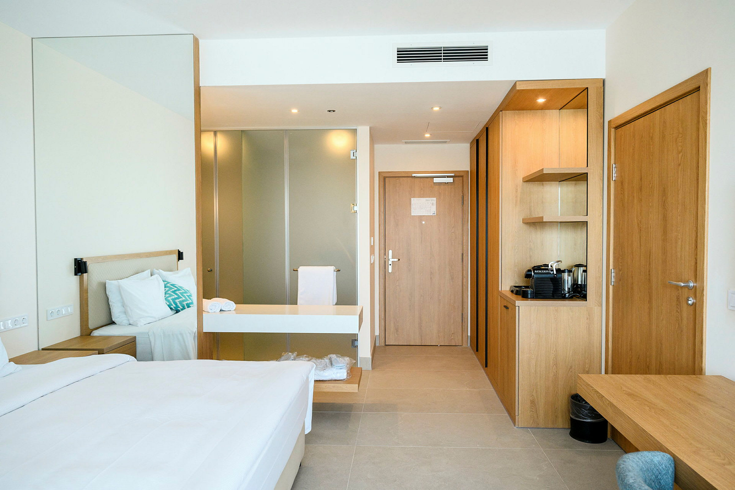 Ett hotellrum med en säng, skrivbord och en liten köksenhet. (AI-genererad text)