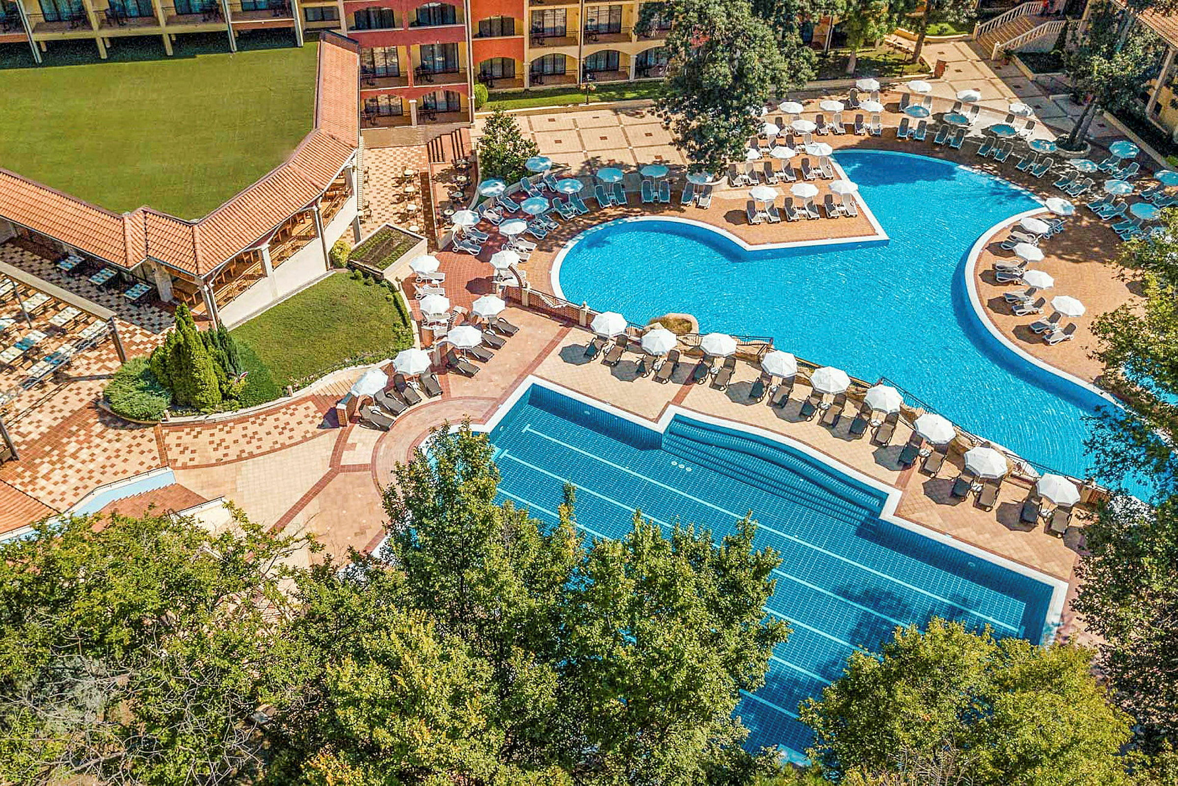 Flygfoto av en hotellpool med solstolar och parasoller. (AI-genererad text)