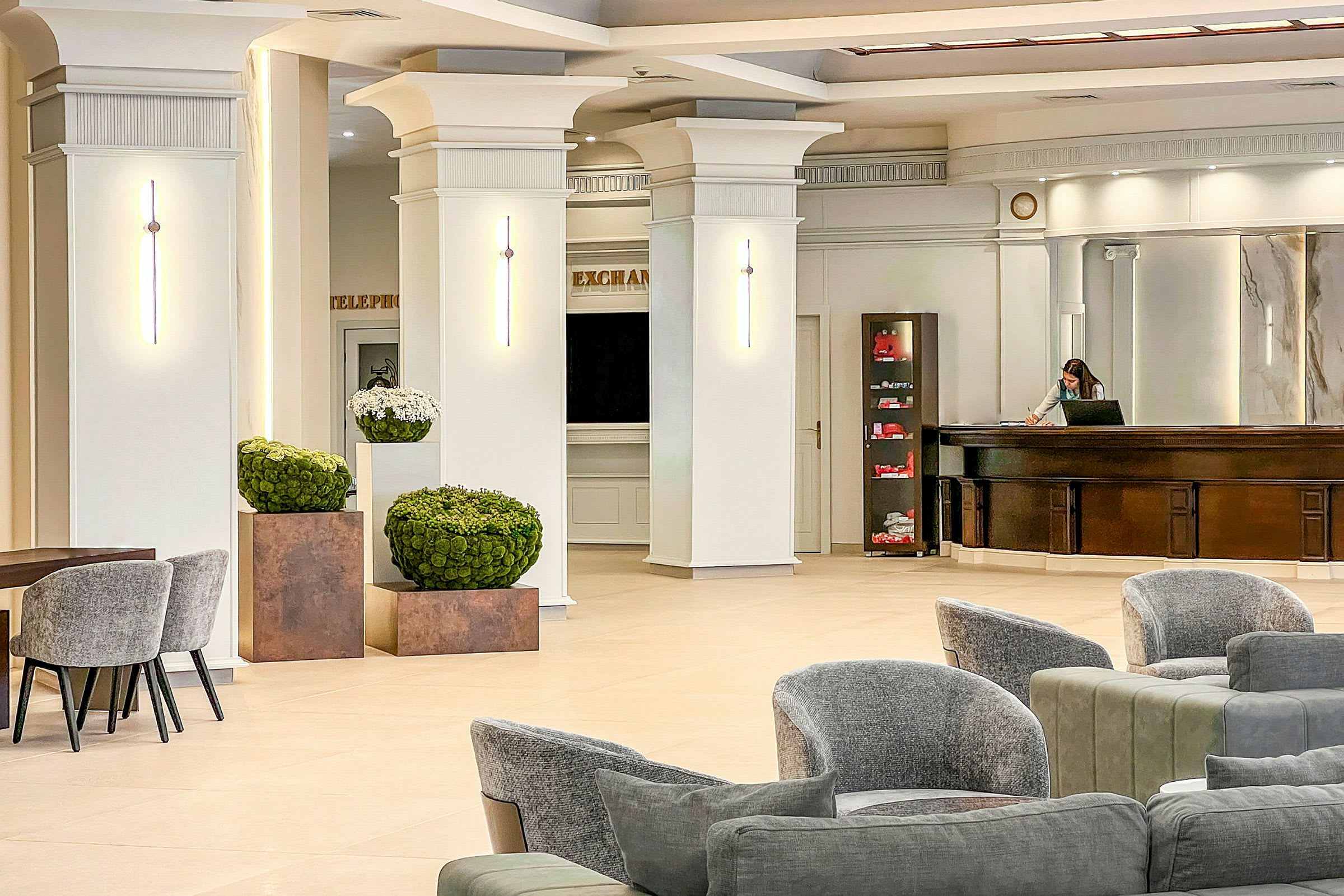 Ljus och rymlig hotellreception med moderna möbler och stilrena väggdetaljer. (AI-genererad text)