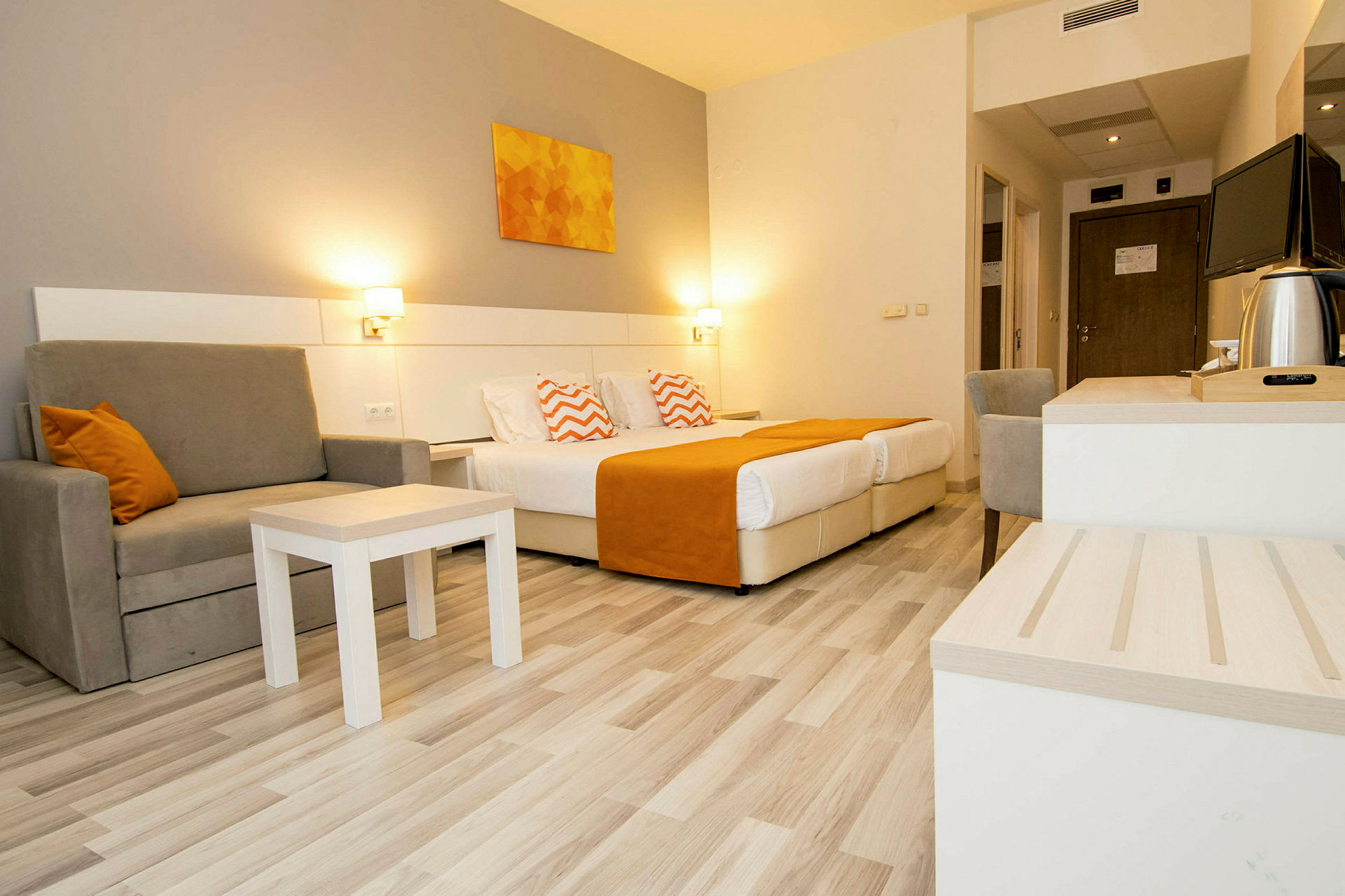 Hotellrum med två bäddar, sittplats och skrivbord. (AI-genererad text)