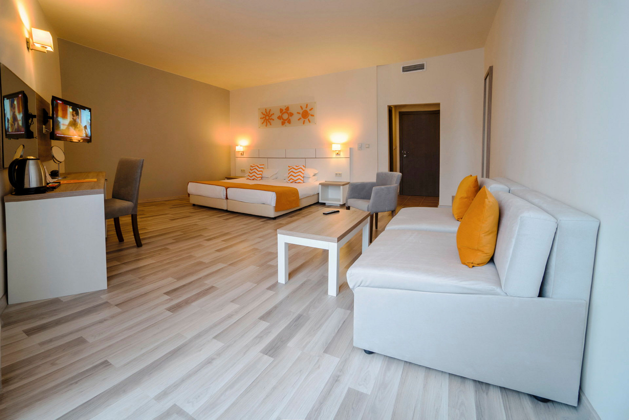 Modernt hotellrum med sängar, soffmöbler och skrivbord. (AI-genererad text)