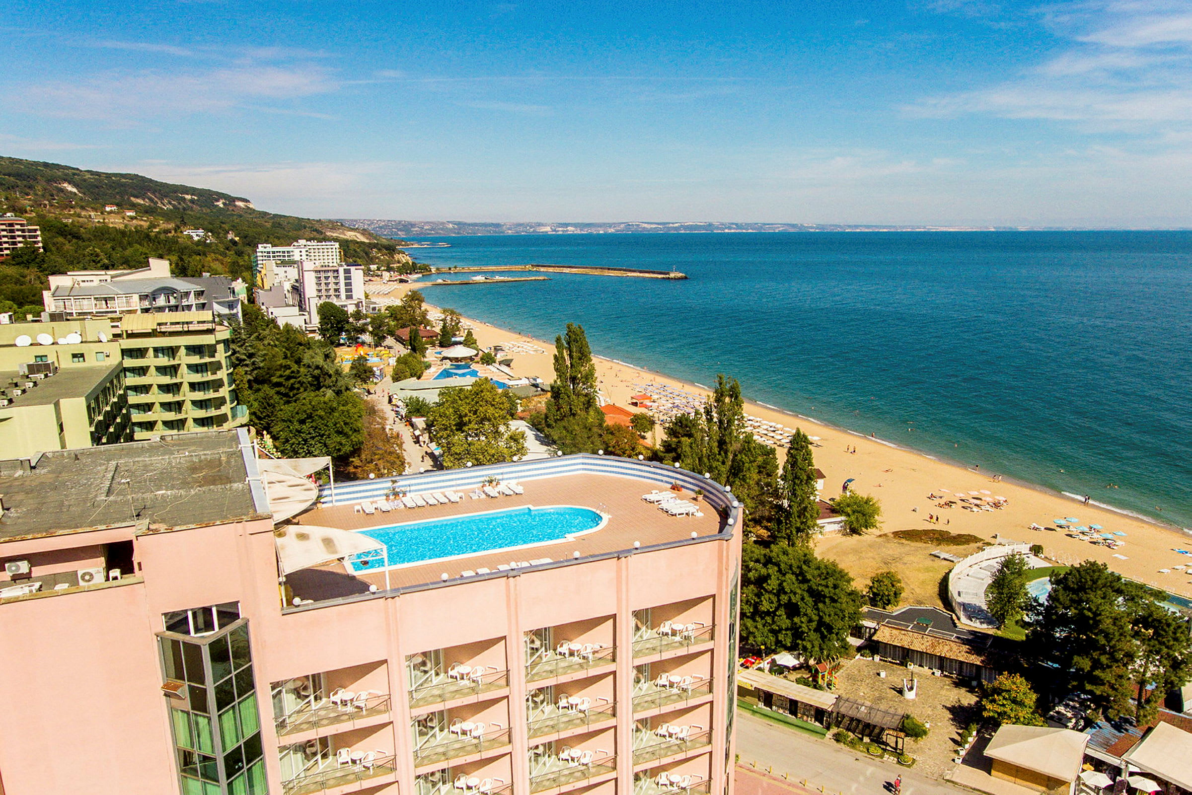 Vy över en strand med hotell och en pool. (AI-genererad text)