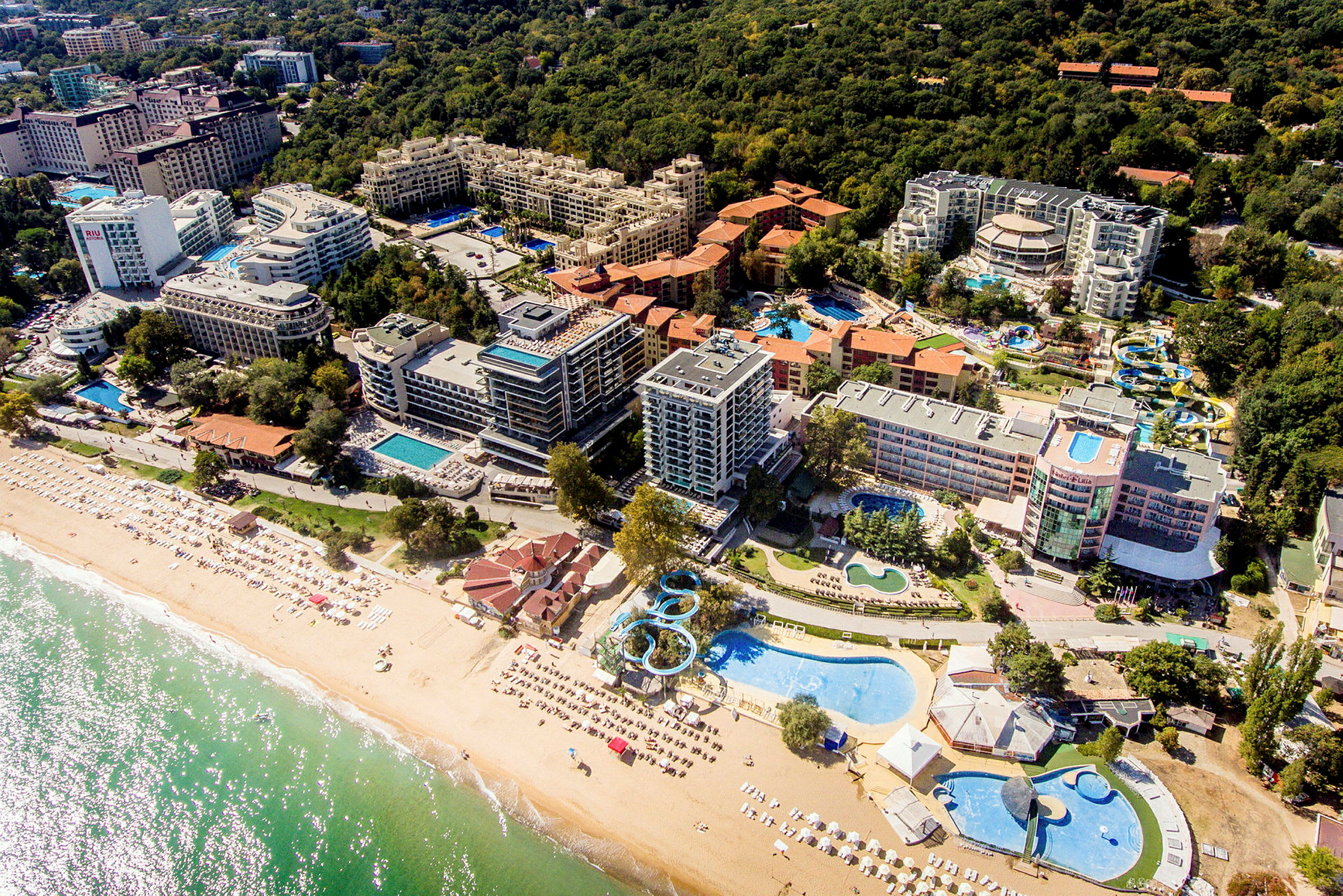 Flygvy över hotellområde vid strand. (AI-genererad text)