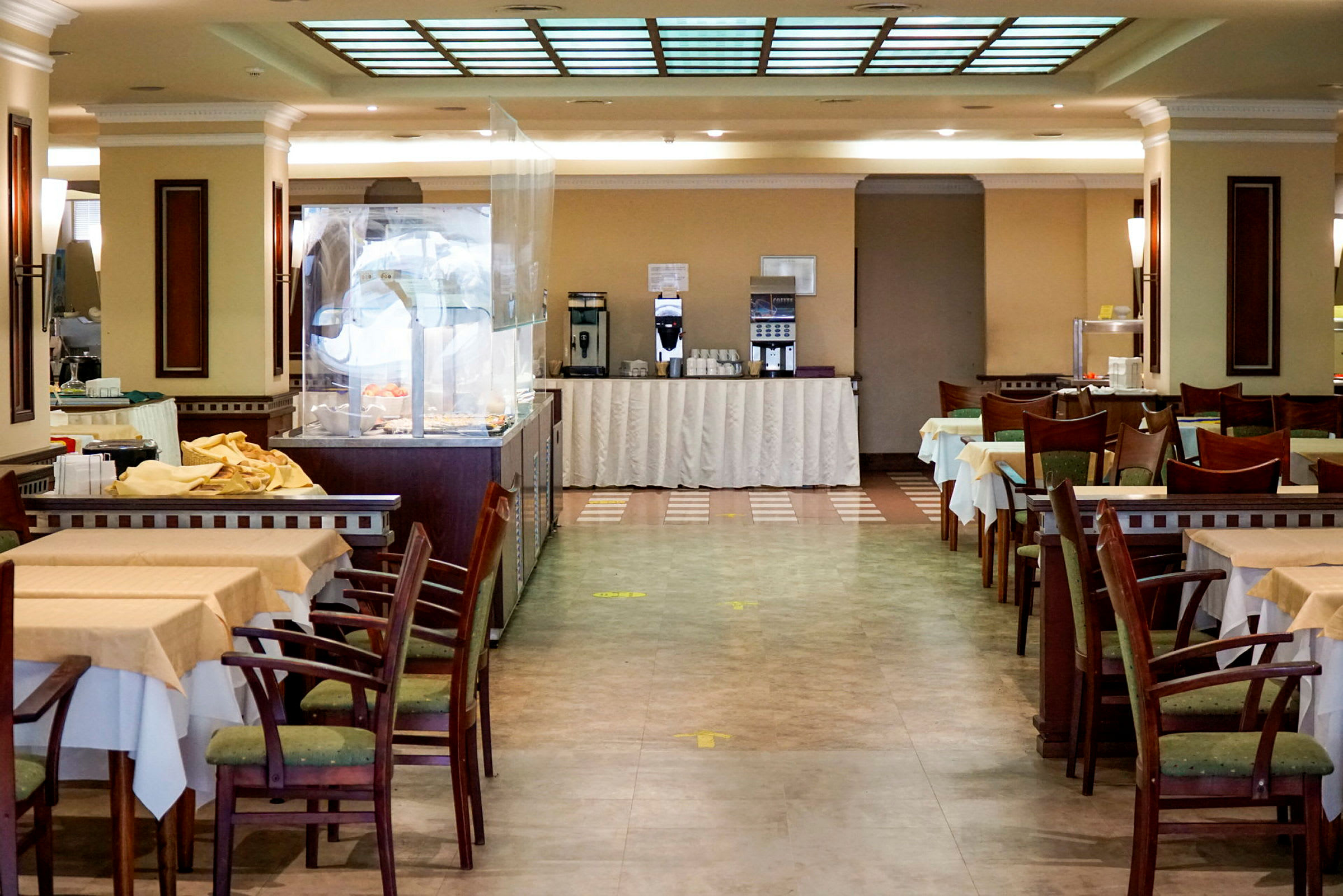 Interiör av en restaurang med dukade bord och stolar. (AI-genererad text)