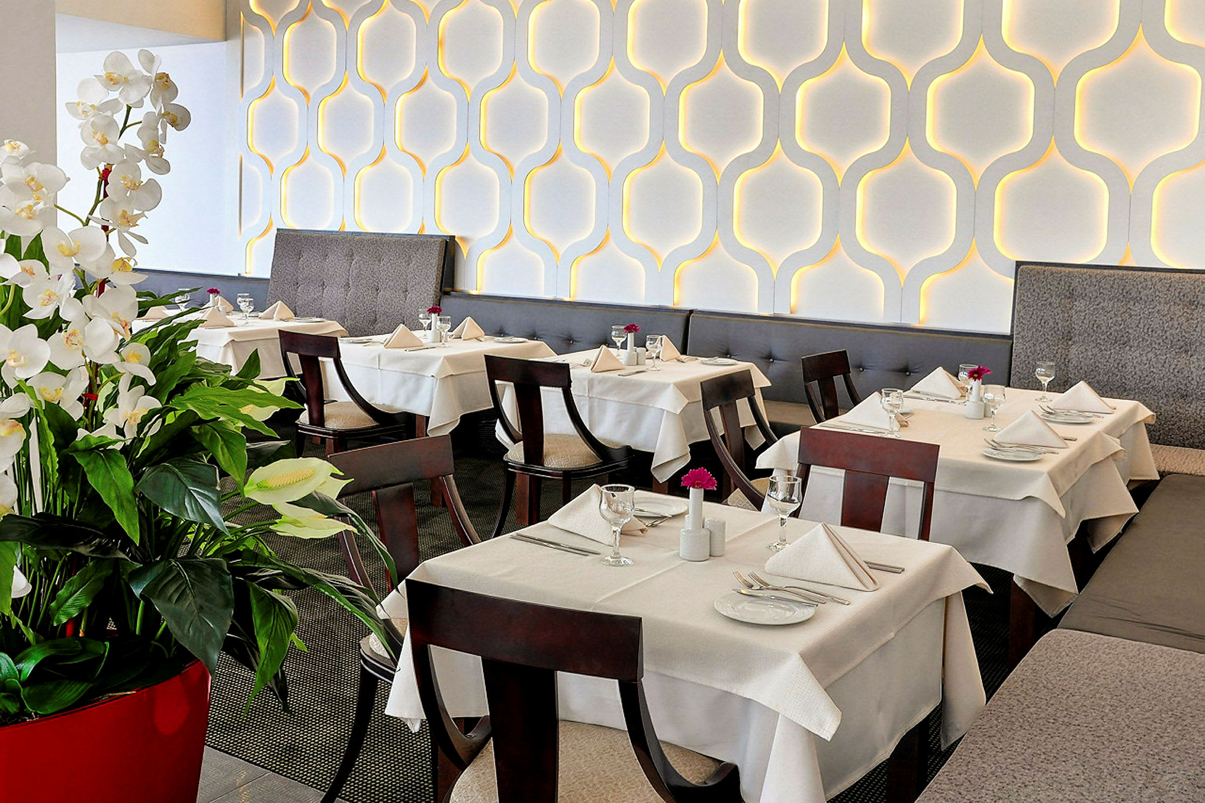 Elegant restaurang med dukade bord och dekorativa vita blommor. (AI-genererad text)