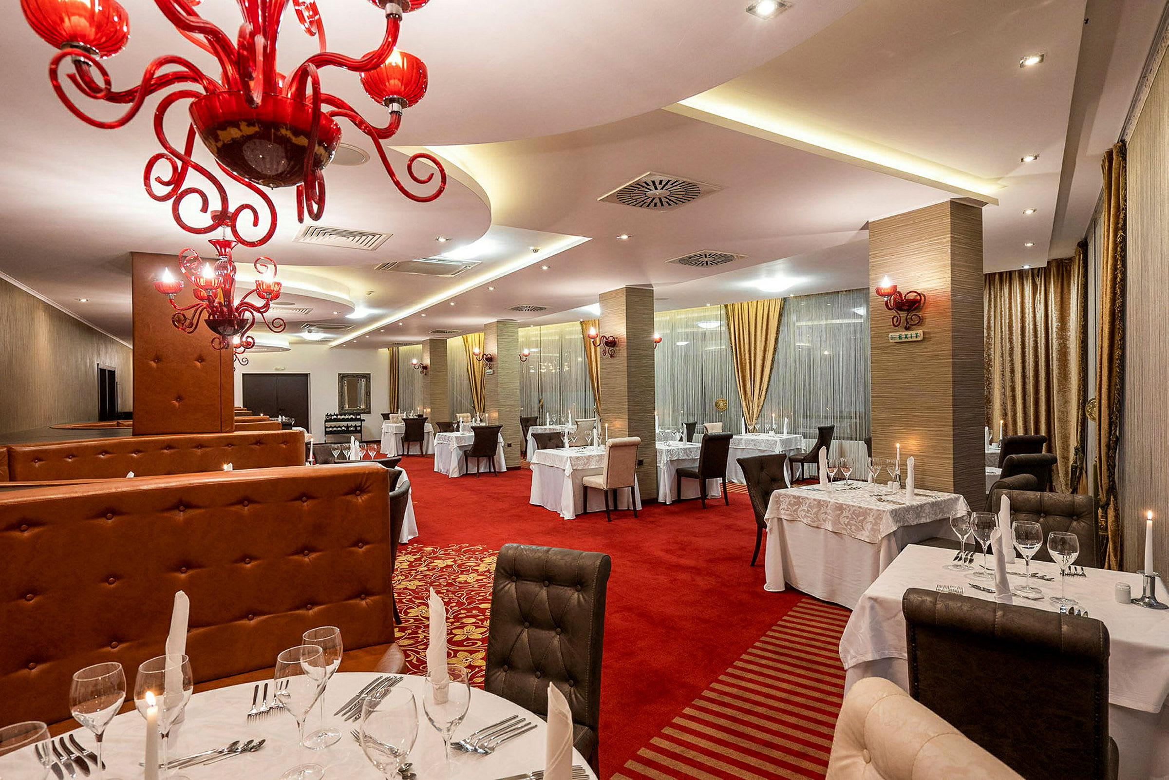 Interiör av en restaurang med röda detaljer och ljusa möbler. (AI-genererad text)