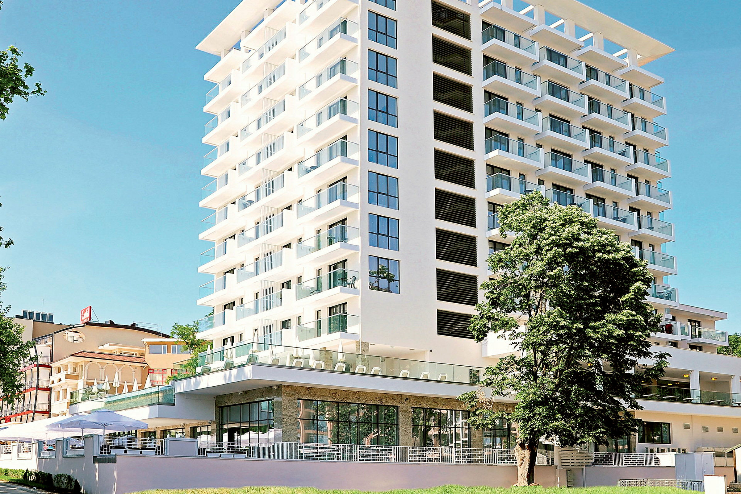 En modern hotellbyggnad med glasbalkonger och stora fönster. (AI-genererad text)