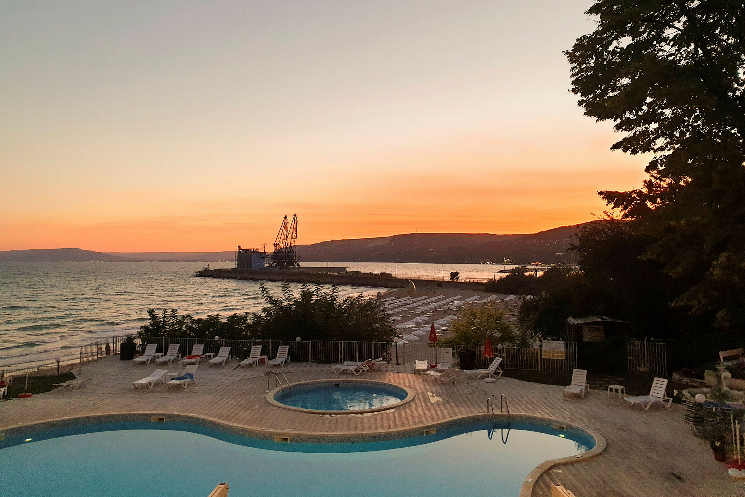 Solnedgång vid havet med en pool i förgrunden. (AI-genererad text)
