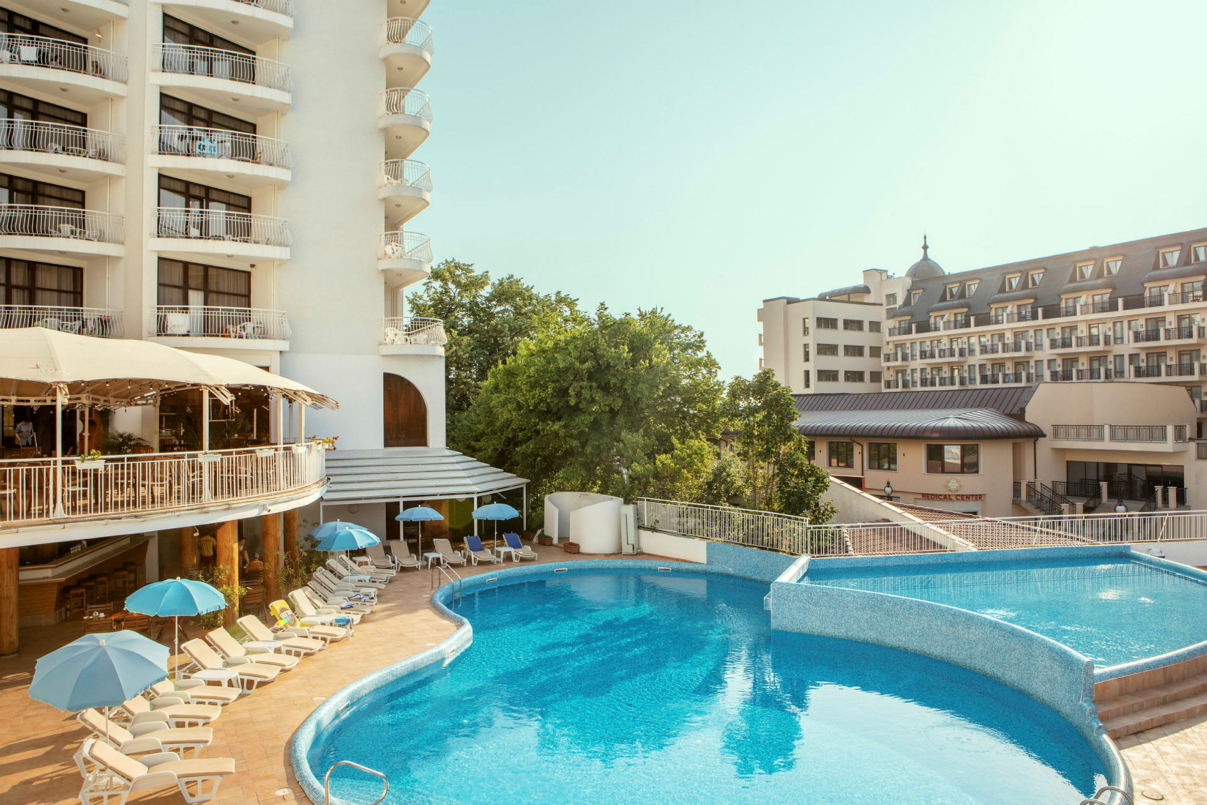 Poolområde med solstolar och parasoller vid ett hotell. (AI-genererad text)