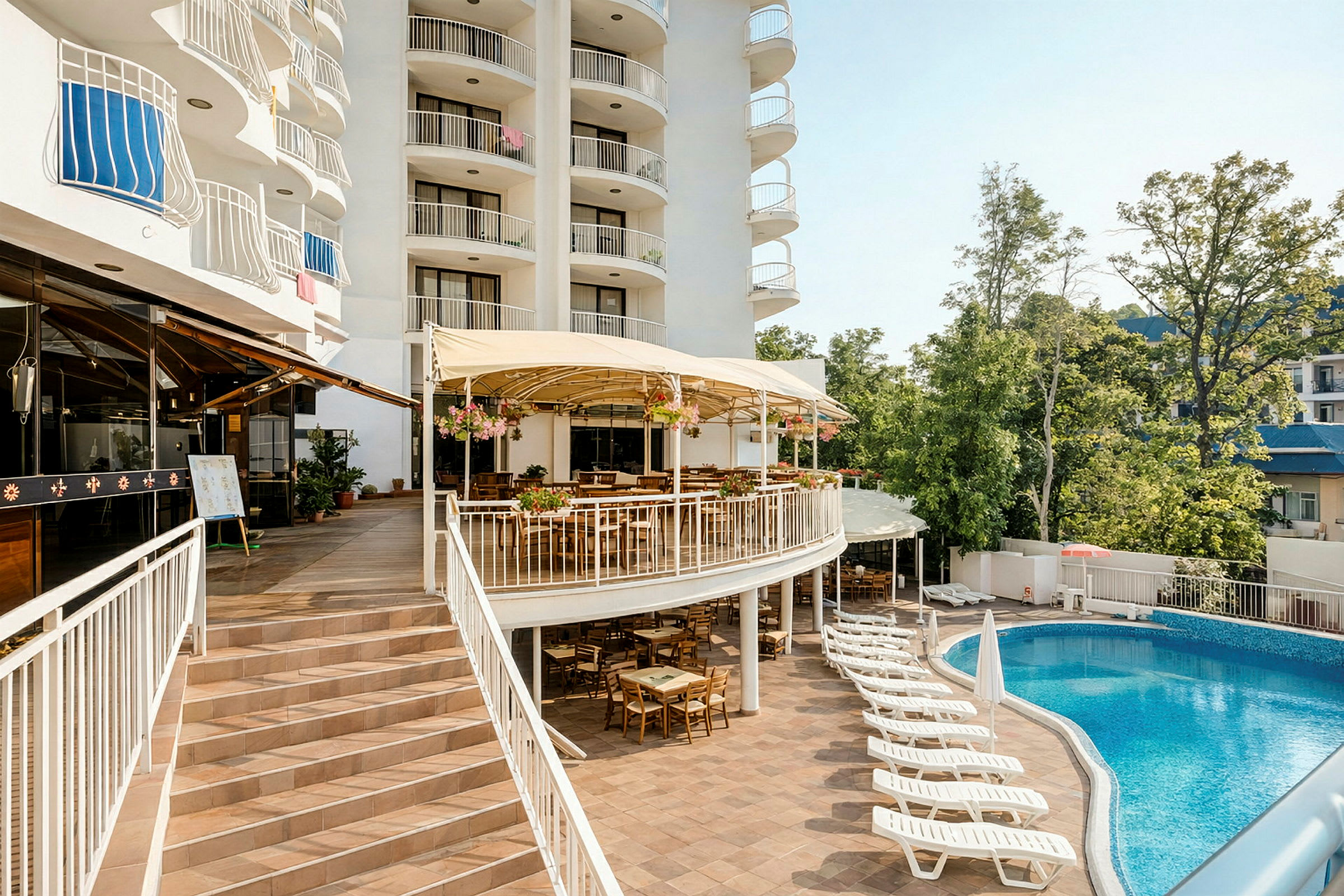 Ett hotell med balkonger, en upphöjd terrass med uteservering samt en pool med solstolar i förgrunden. (AI-genererad text)