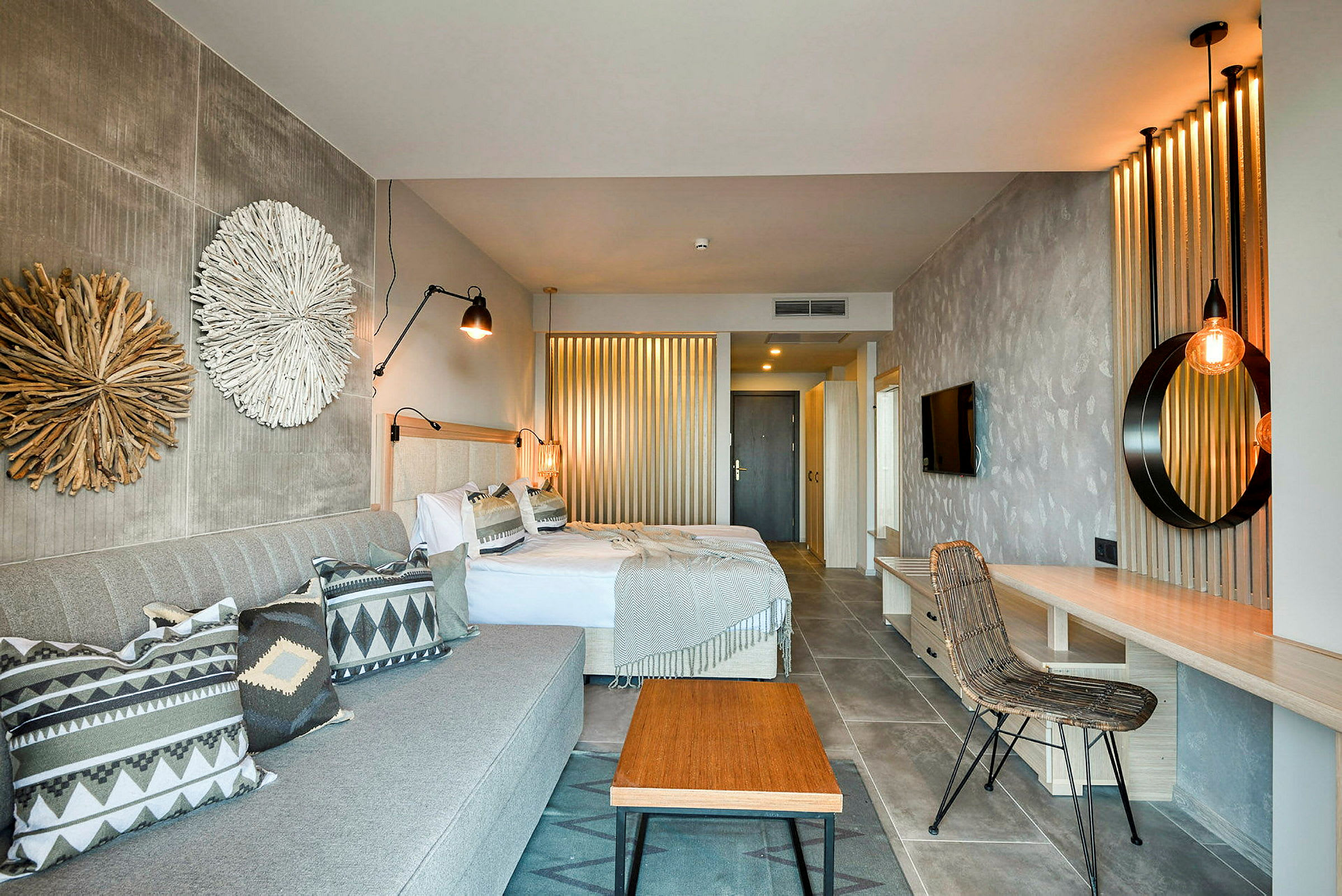 Ett hotellrum med två sängar, en soffa och inredningsdetaljer. (AI-genererad text)