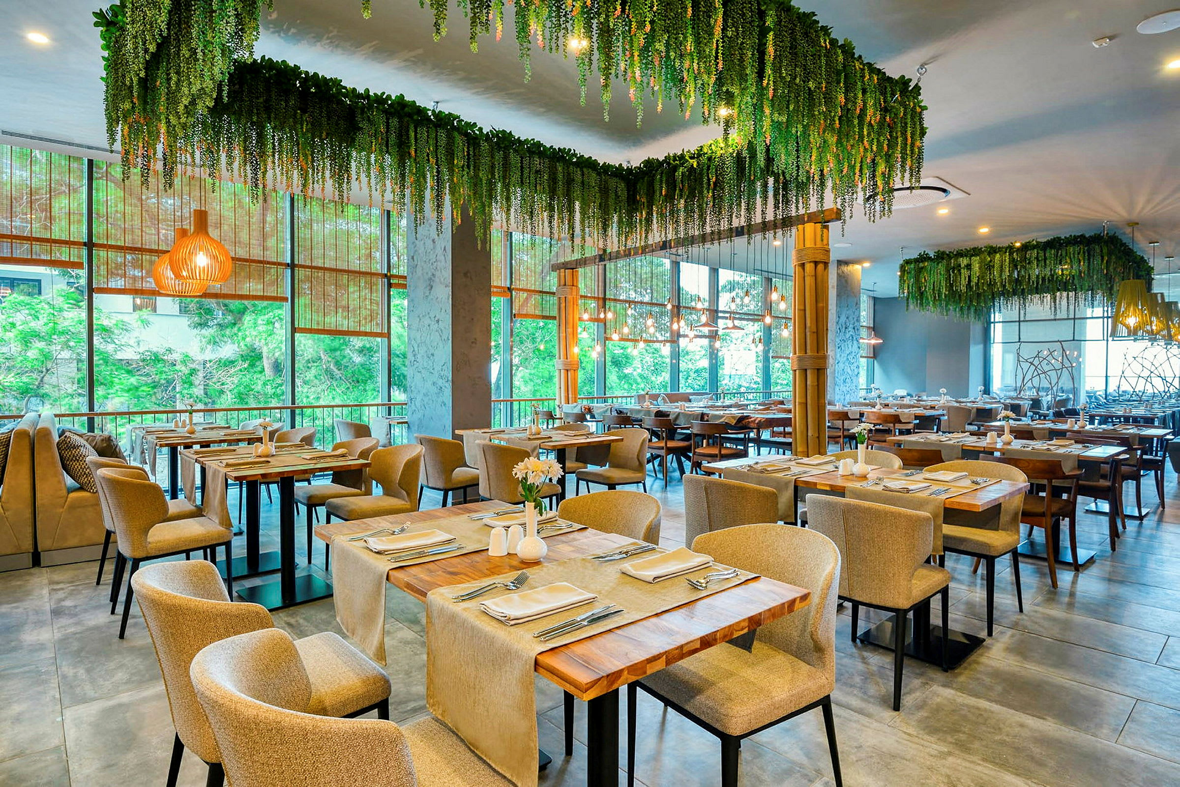 Restaurang med dukade bord och hängande grönska. (AI-genererad text)