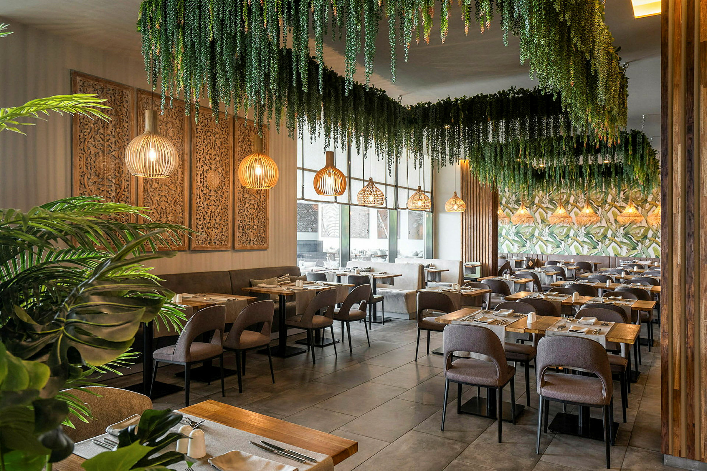 Interiör av en restaurang med dekorativa växter och trämöbler. (AI-genererad text)