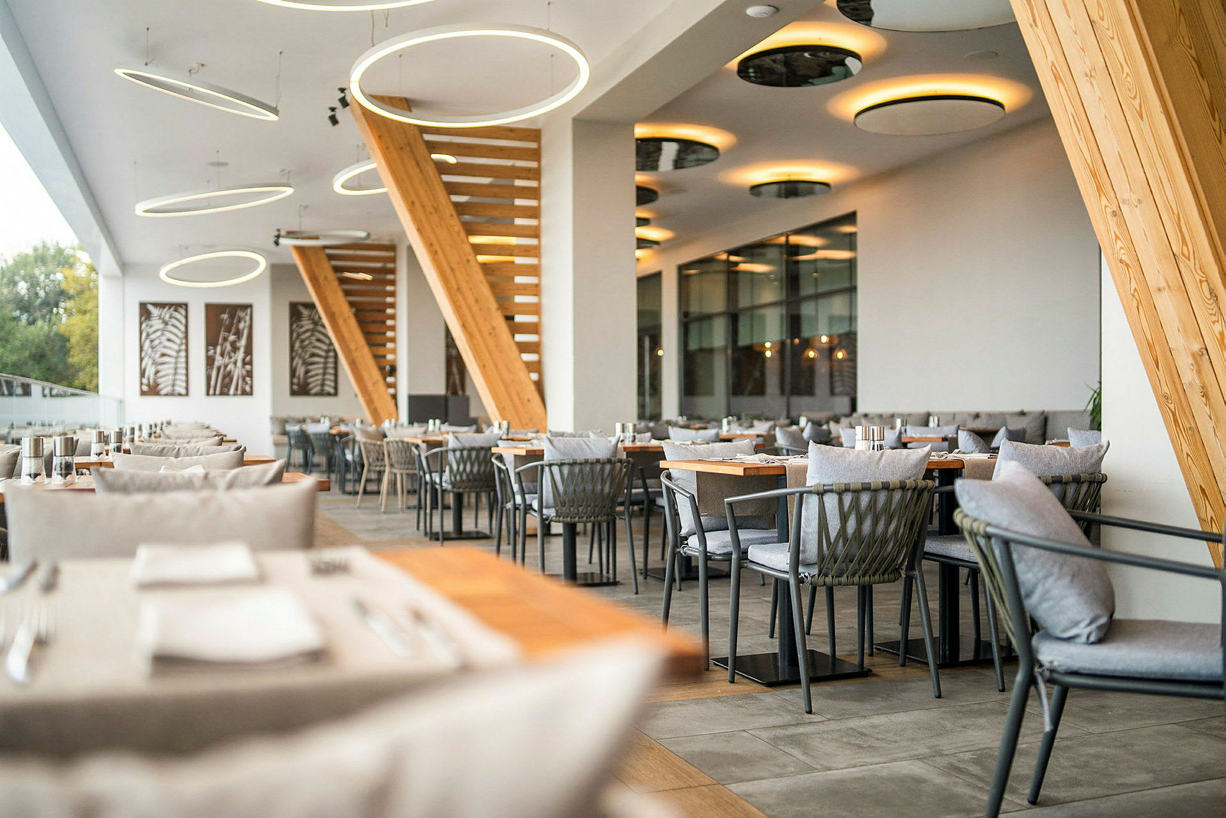 Bild av en modern restaurang med stilfull inredning, trädetaljer och hängande ljuskällor. (AI-genererad text)