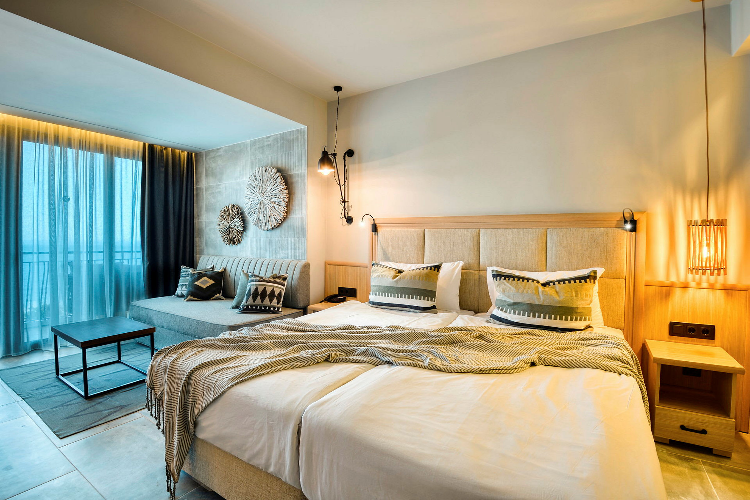 Ett hotellrum med en dubbelsäng, sittgrupp och modern inredning. (AI-genererad text)