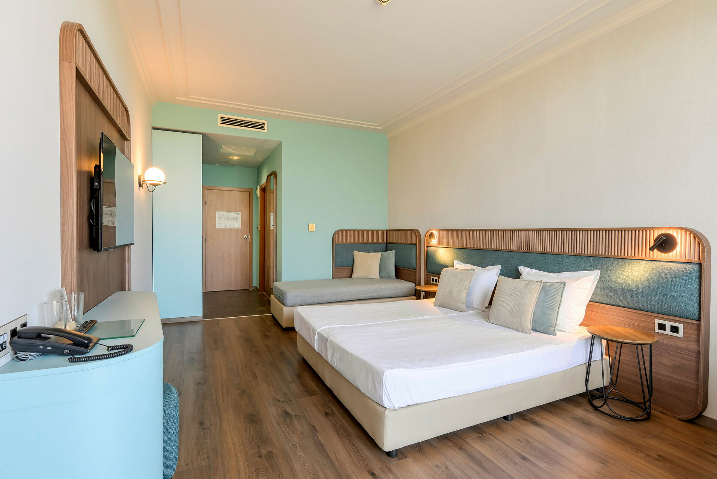 Ett hotellrum med två sängar och en soffa. (AI-genererad text)