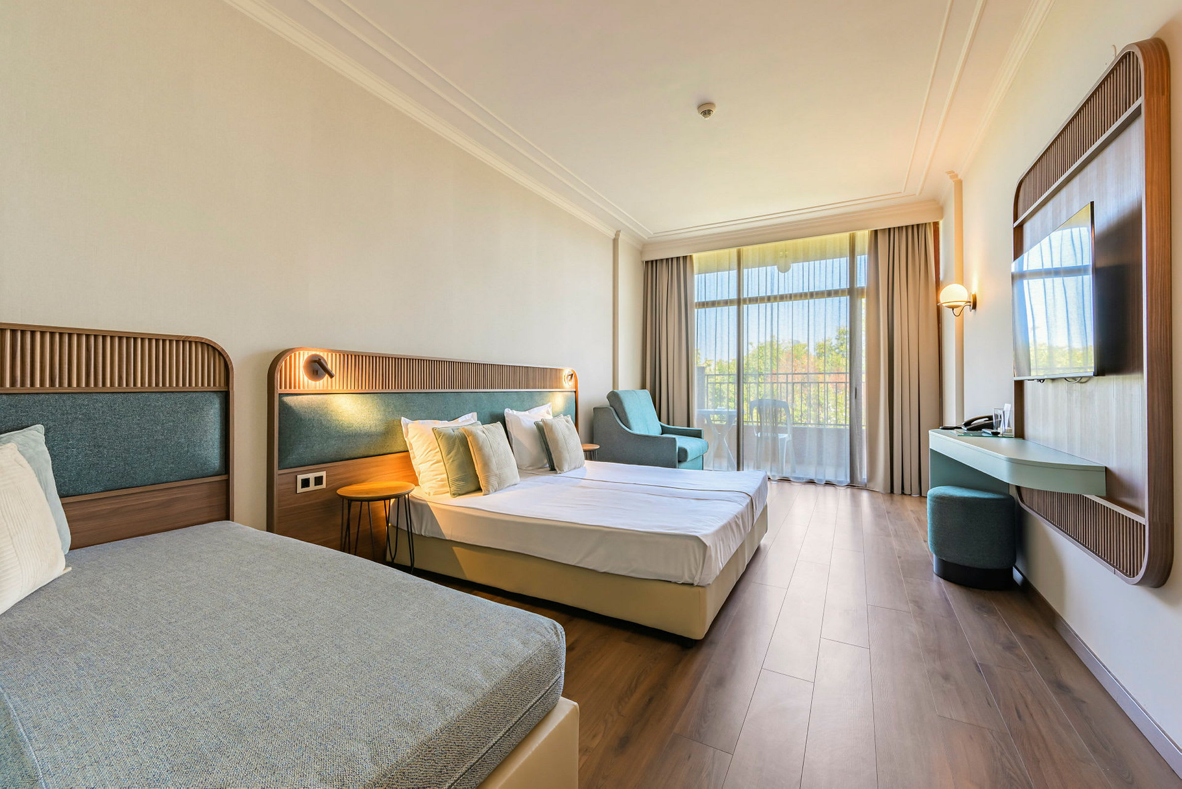 Ett hotellrum med två sängar, sittmöbler och en balkong. (AI-genererad text)
