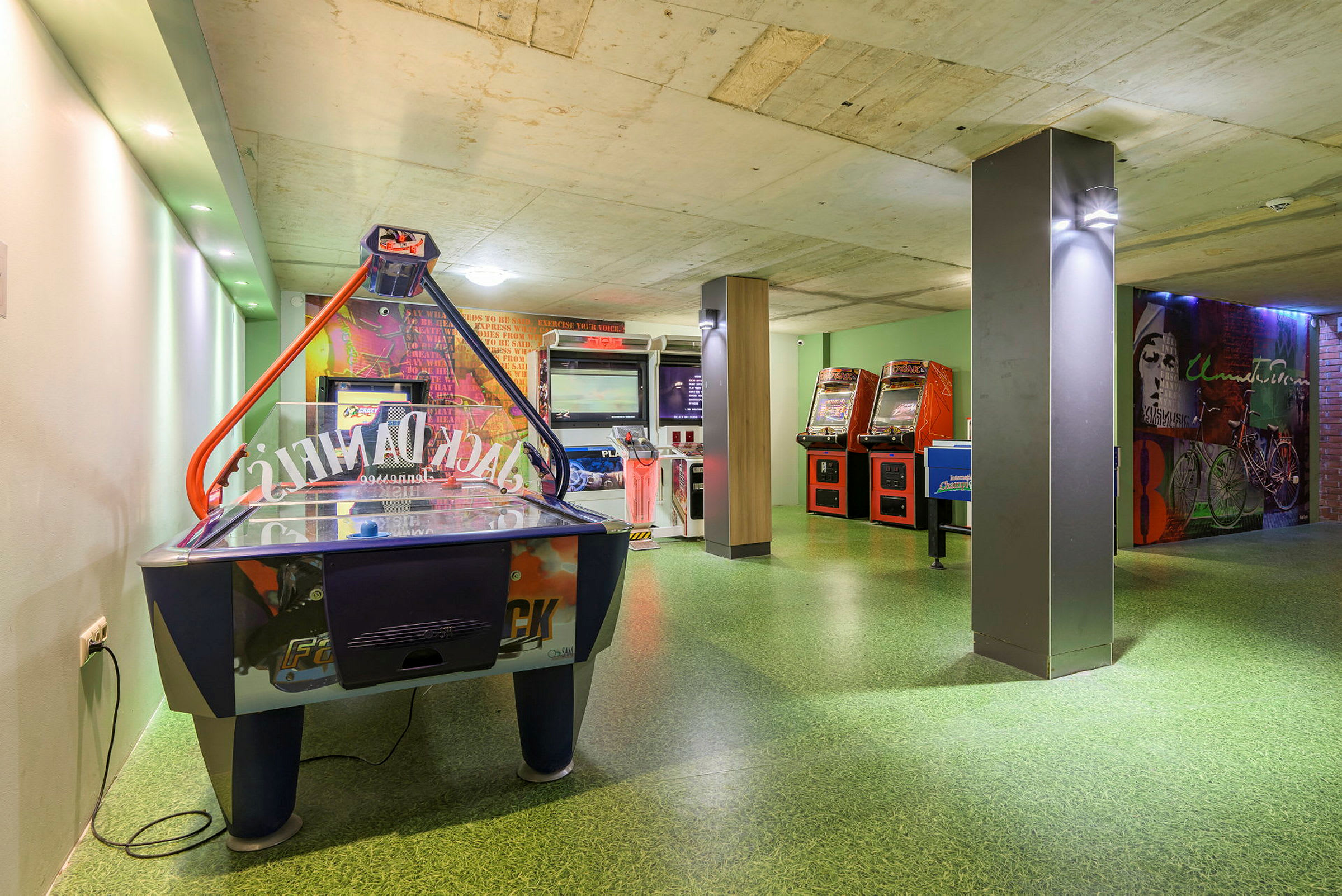 Bild på ett spelrum med luftpuckspel och arkadmaskiner. (AI-genererad text)